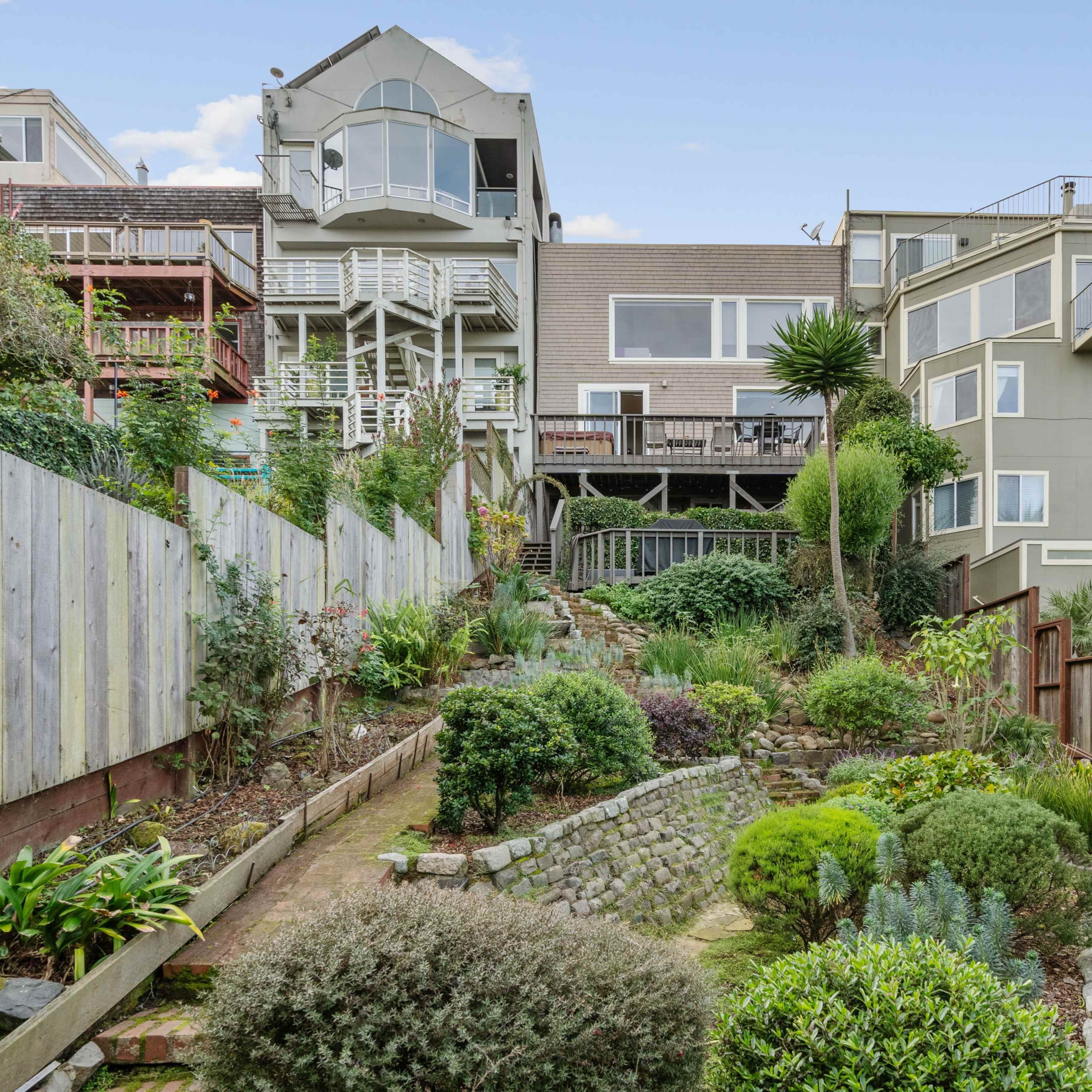 A landscaped garden with a terraced design, leading up to multiple modern buildings.