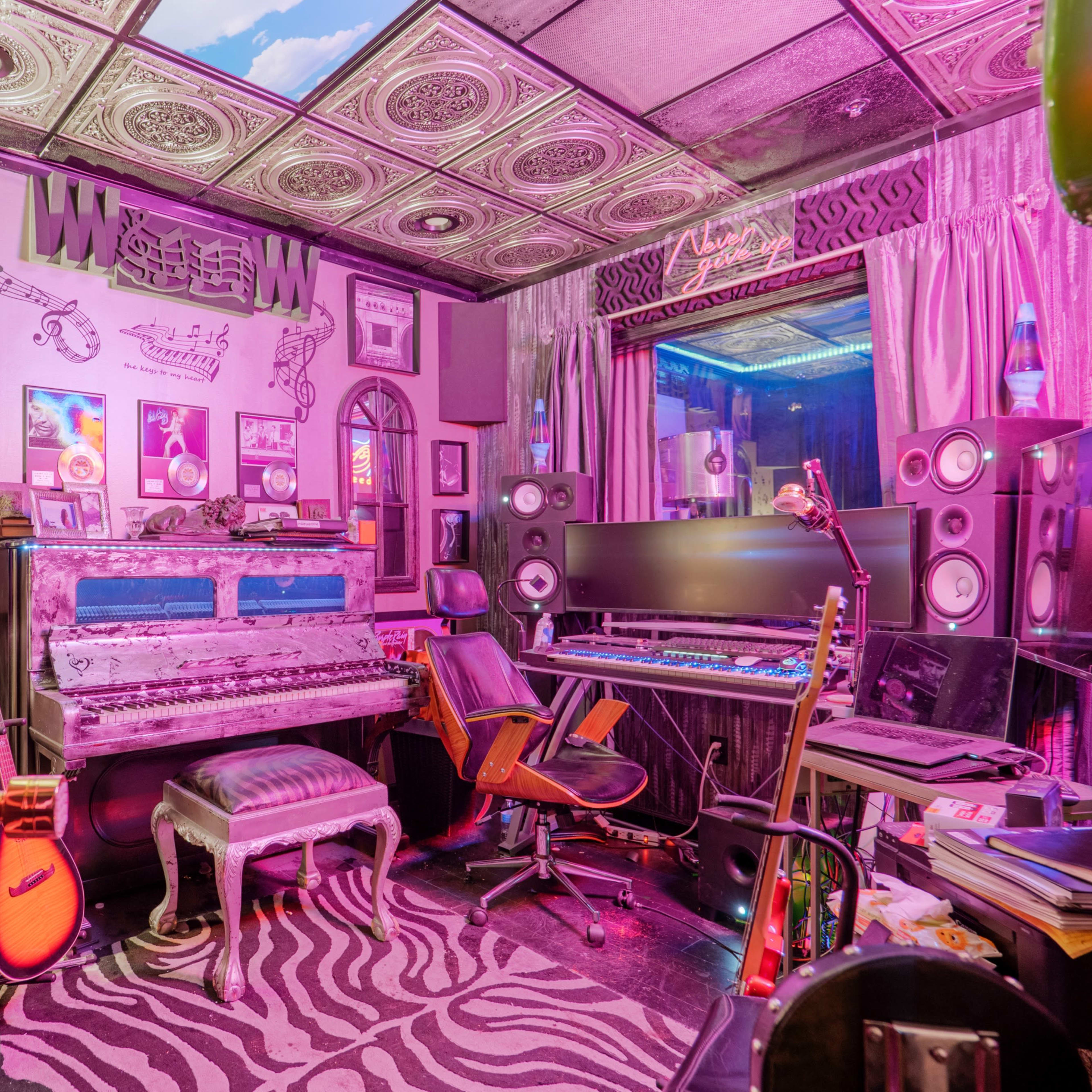A colorful music studio featuring a vintage piano, recording equipment, and eclectic decor, all illuminated by vibrant lighting.
