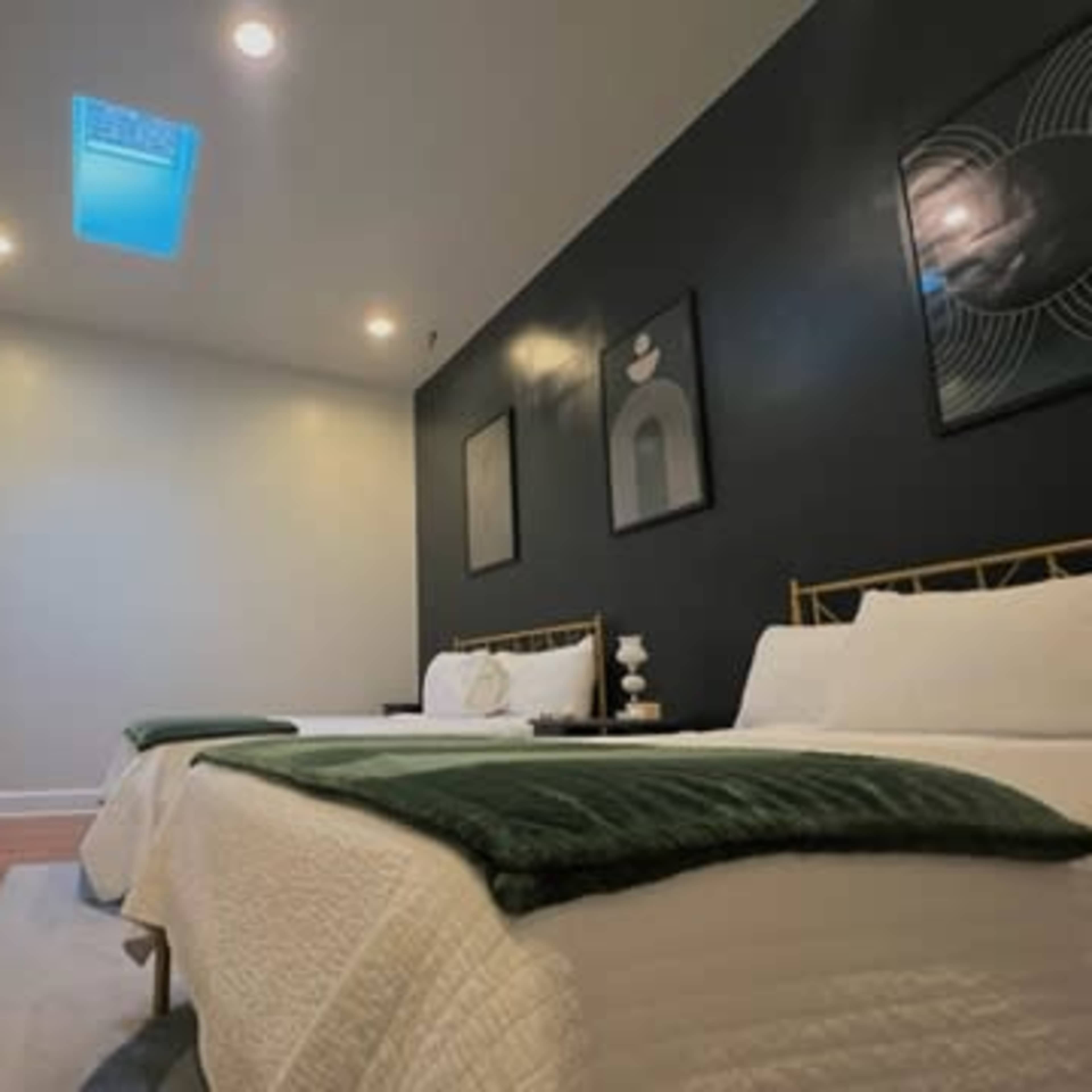 A hotel room with two beds, a flat-screen TV on the wall, and artwork hanging above the beds.