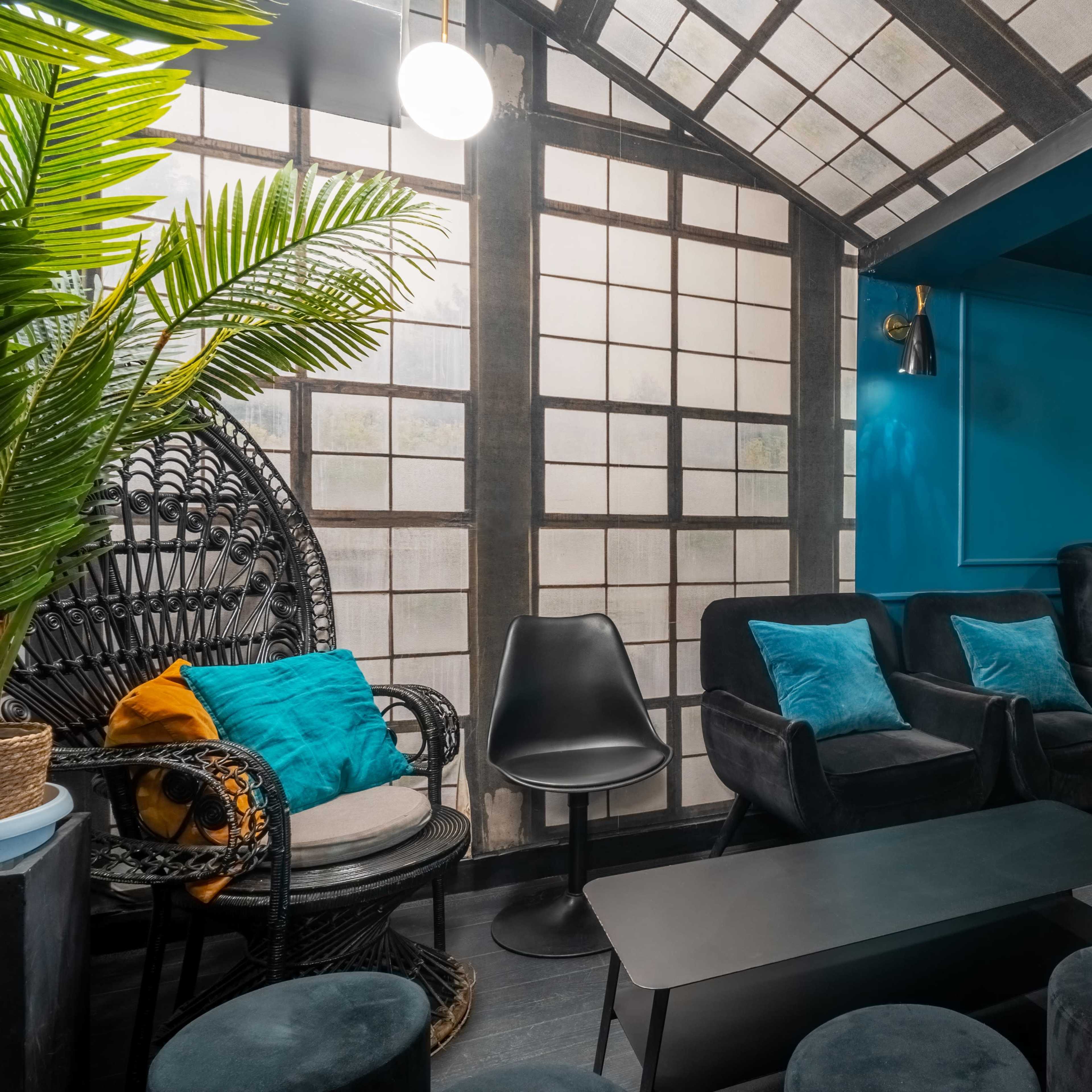 A modern lounge with dark furniture, a distinctive patterned wall, and large windows allowing natural light to fill the space.