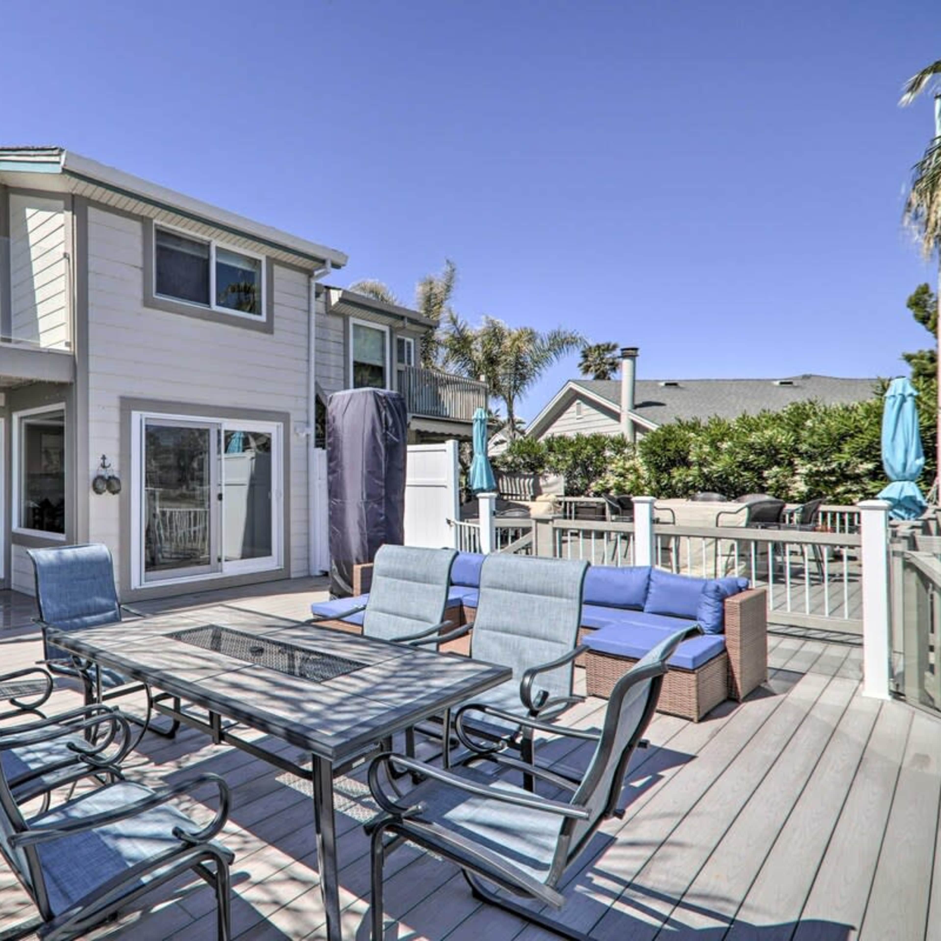 A two-story house with a deck features outdoor seating and access to a backyard area.