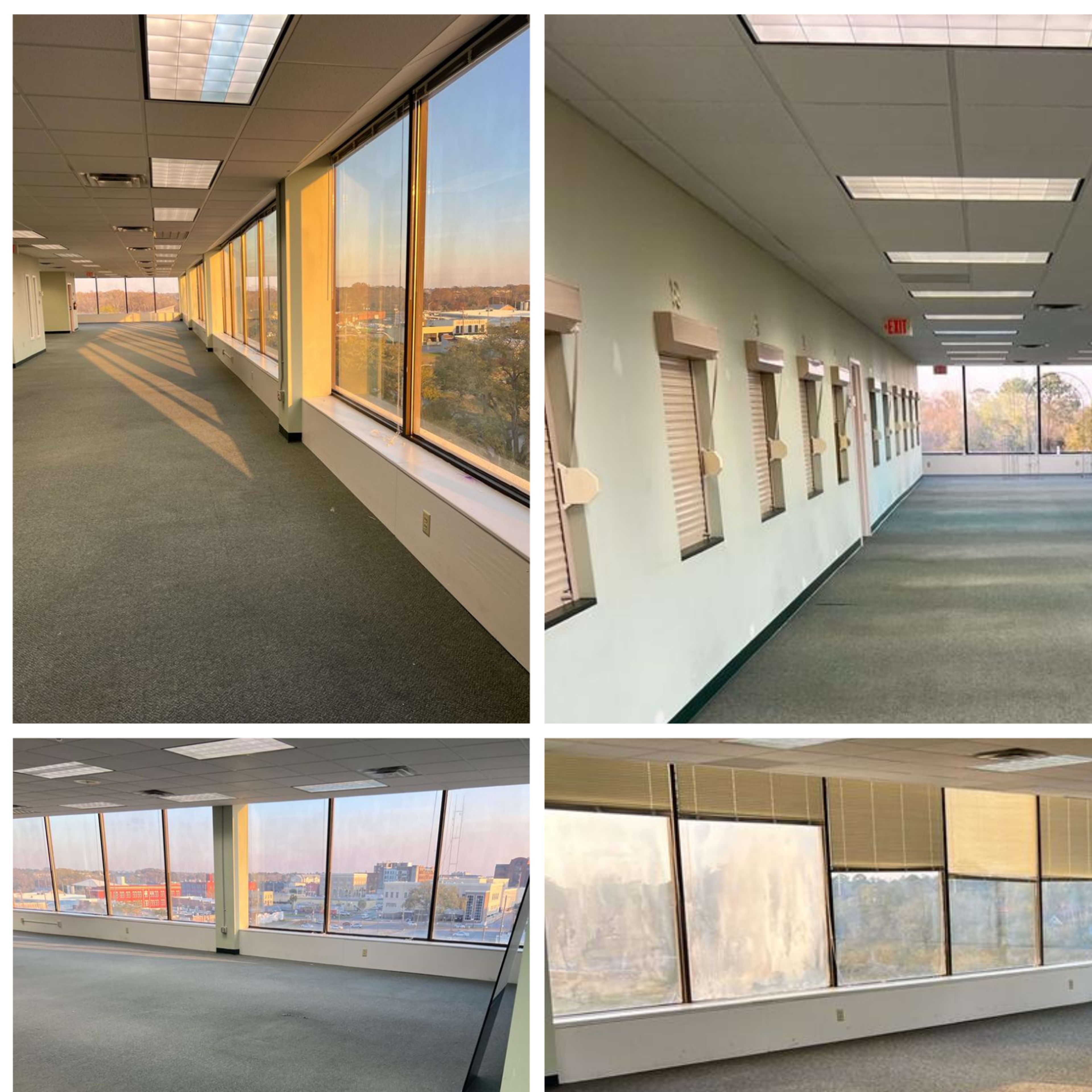 An empty office space featuring large windows, carpeted flooring, and fluorescent lights in a well-lit environment.