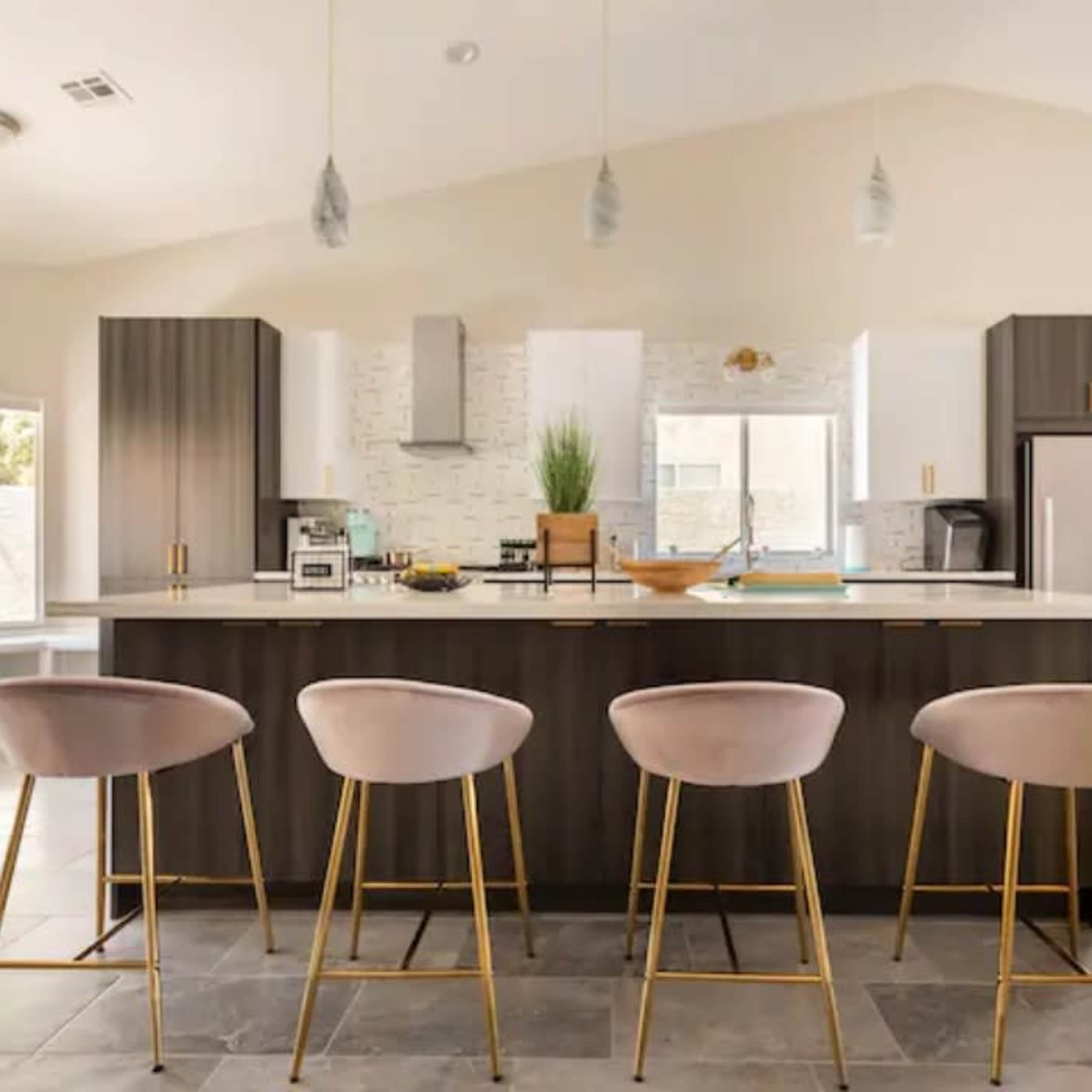 A modern kitchen features a central island with four upholstered bar stools, surrounded by sleek cabinetry and large windows.