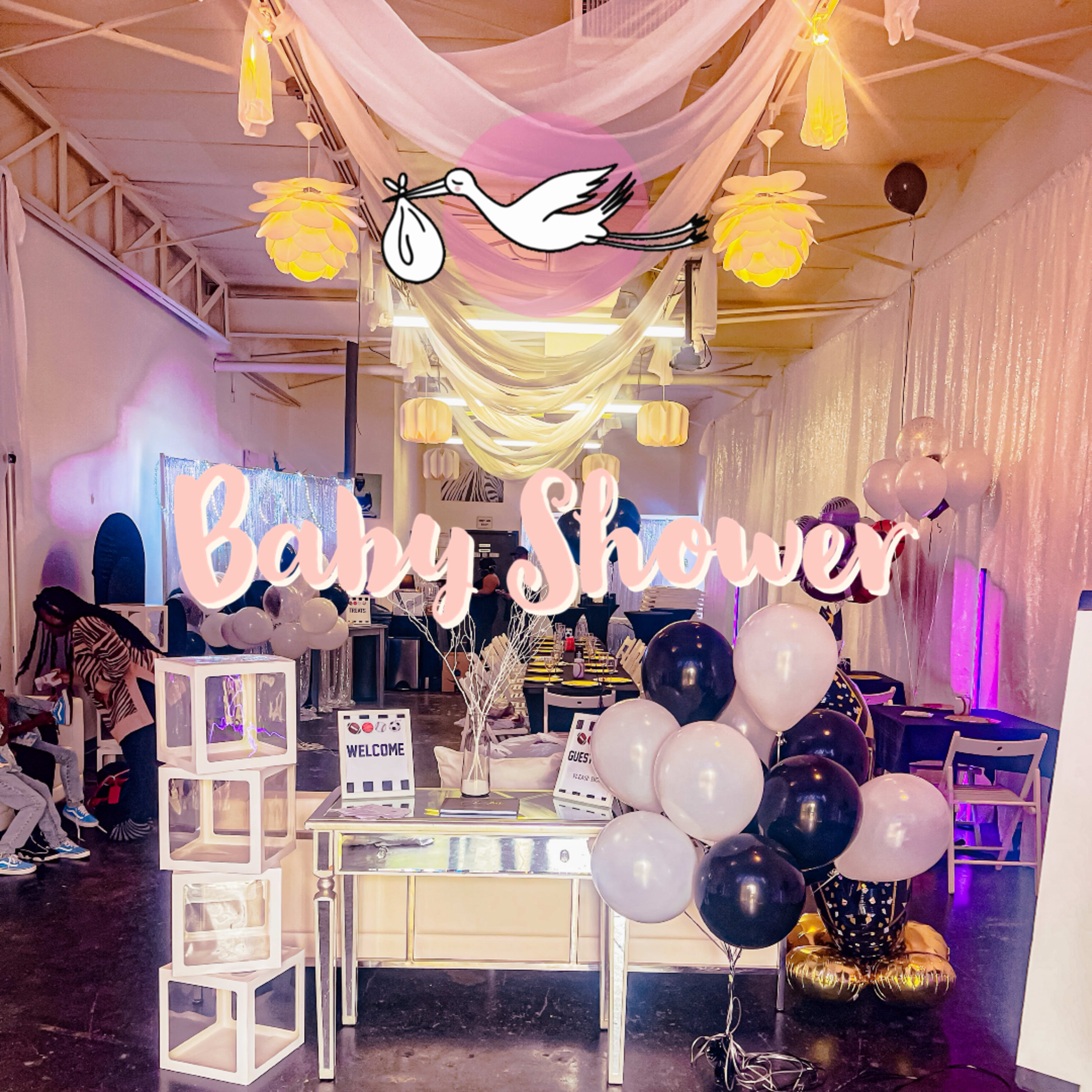 A beautifully decorated venue for a baby shower, featuring balloons, a welcoming sign, and festive drapery.