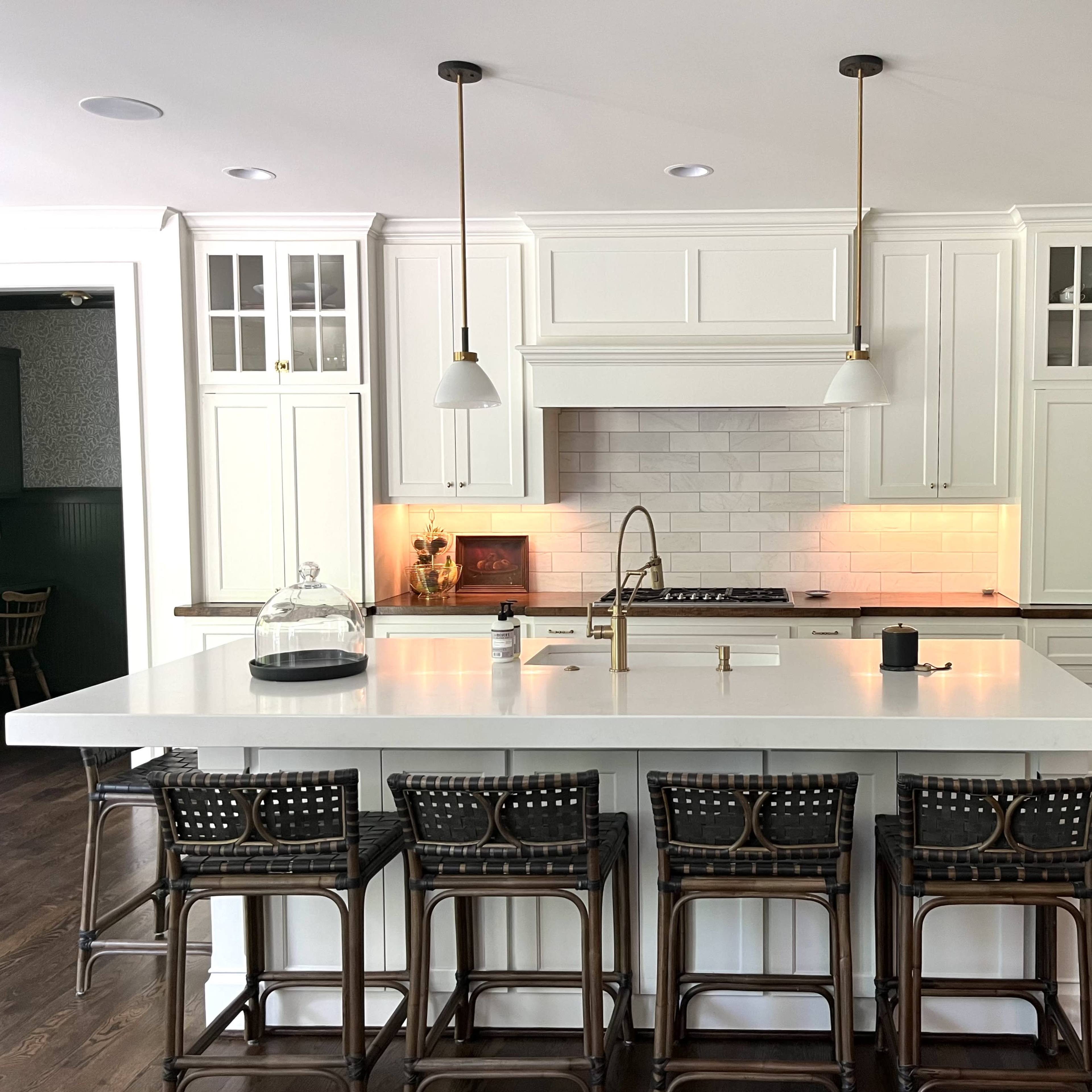 The kitchen features white cabinetry, a large island with bar seating, and modern appliances.