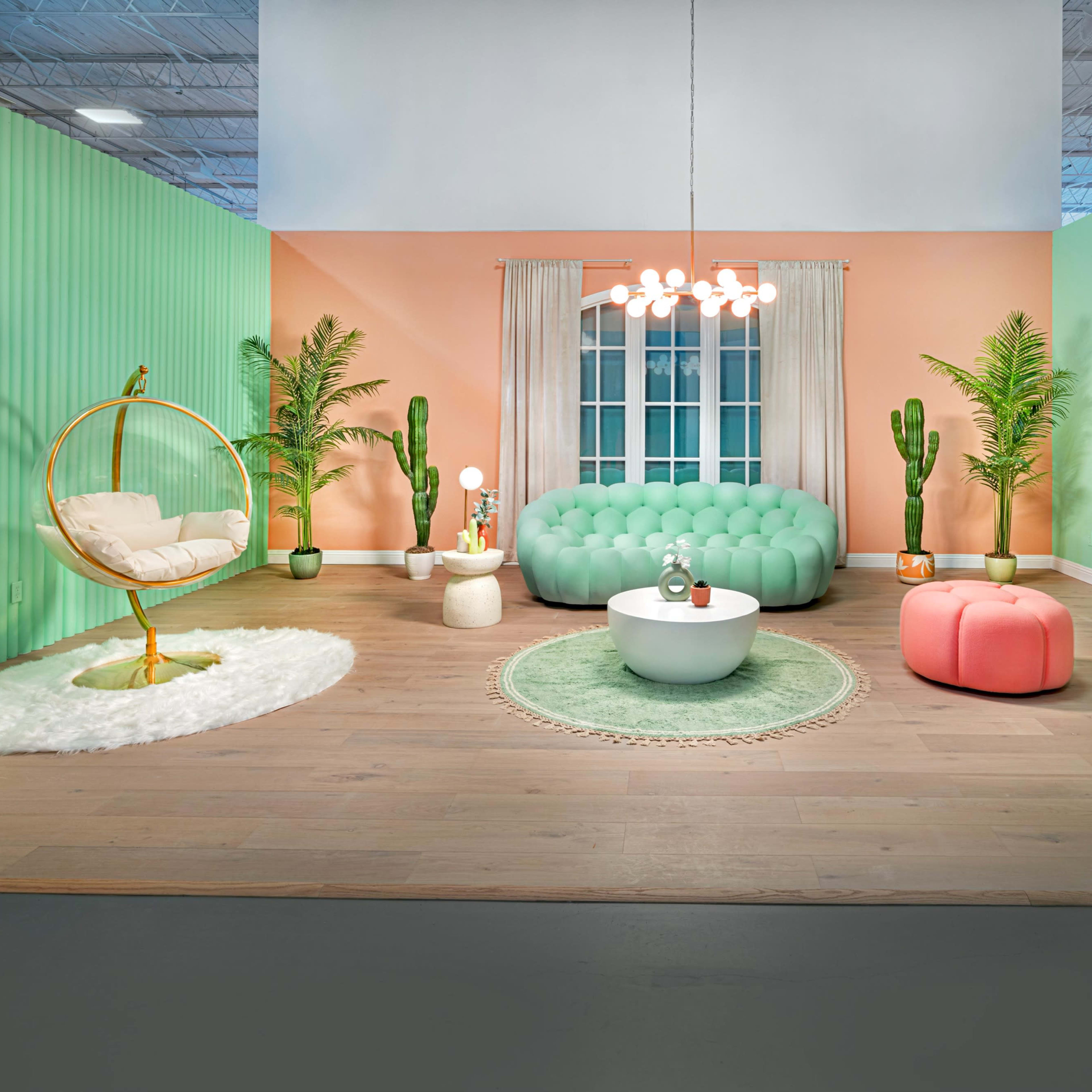 A vibrant living space featuring a green and peach color palette, a tufted green sofa, various plants, and modern furniture.