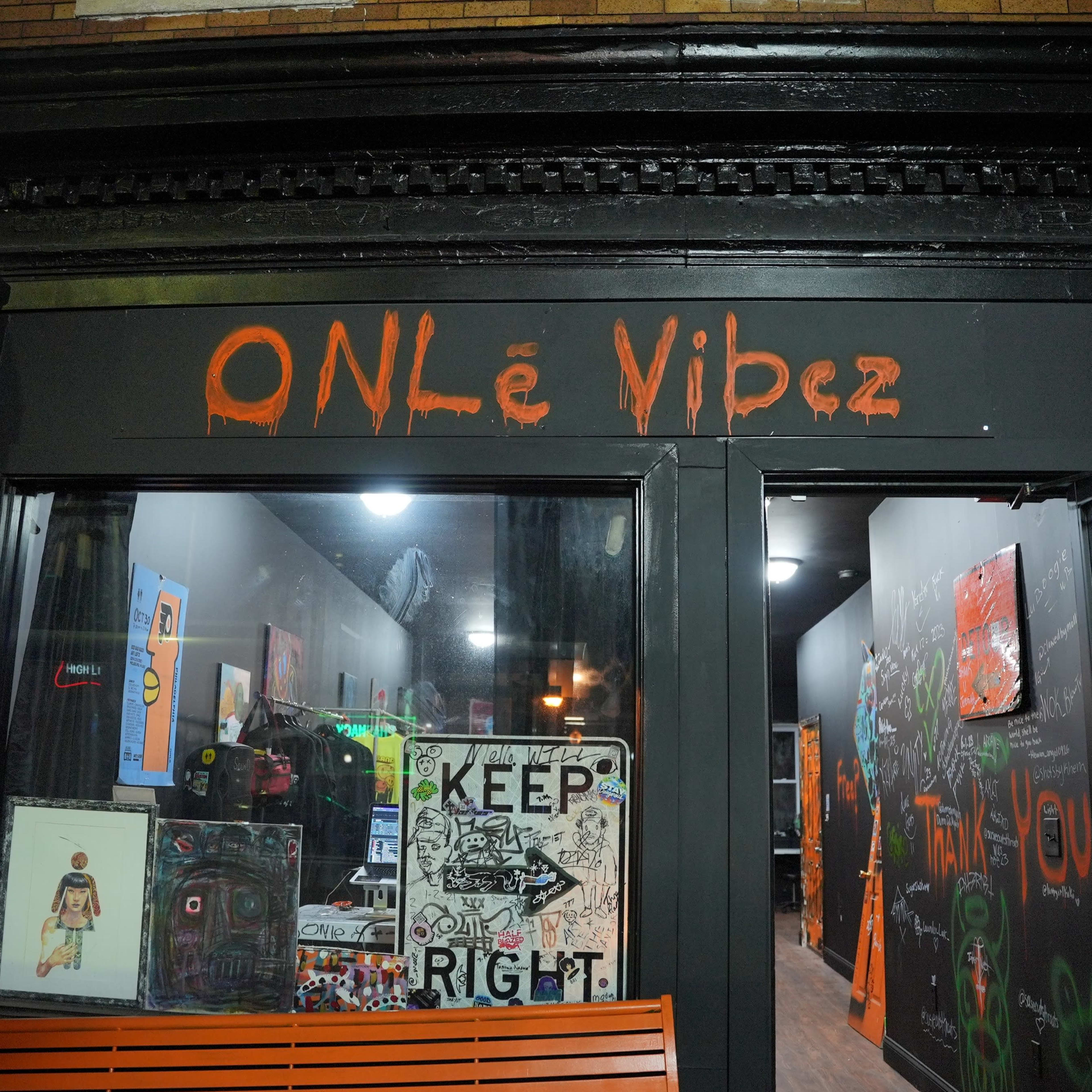 The storefront features a sign that reads "ONLé Vibez," with a display of artwork and signage visible through the large window.