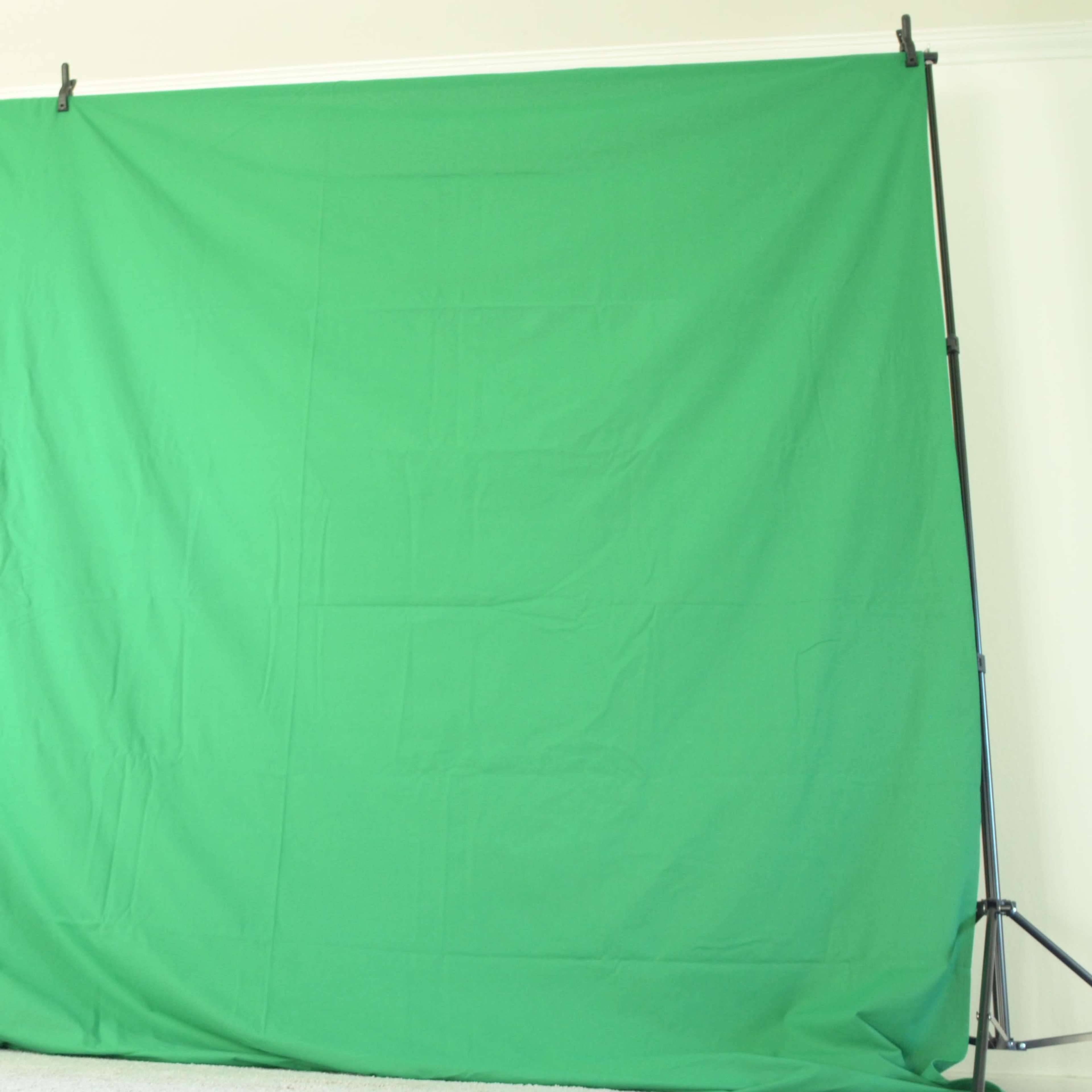 A green backdrop draped on a frame, typically used for video production or photography.