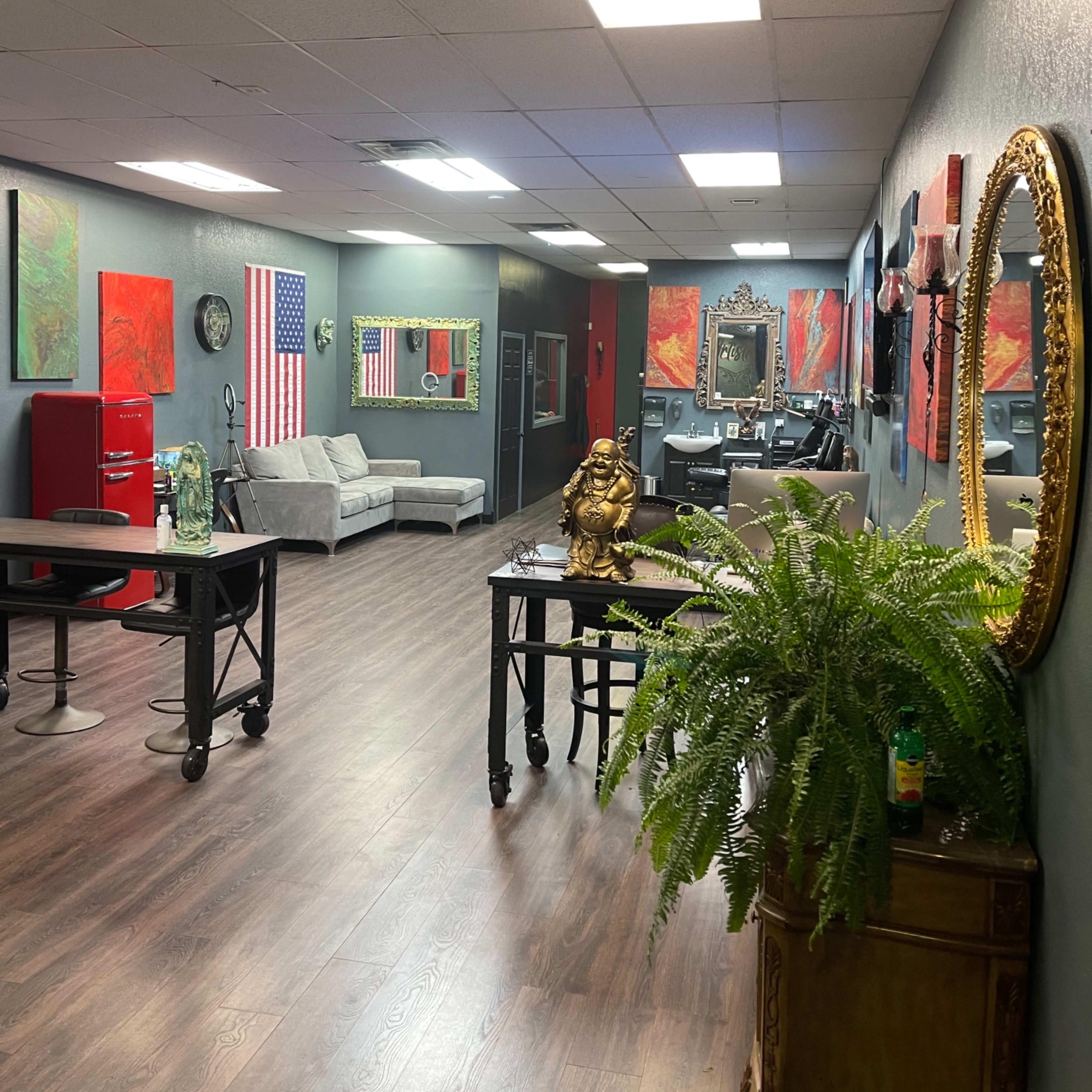 A spacious interior with a reception area featuring two couches, artwork on the walls, and a decorative mirror.