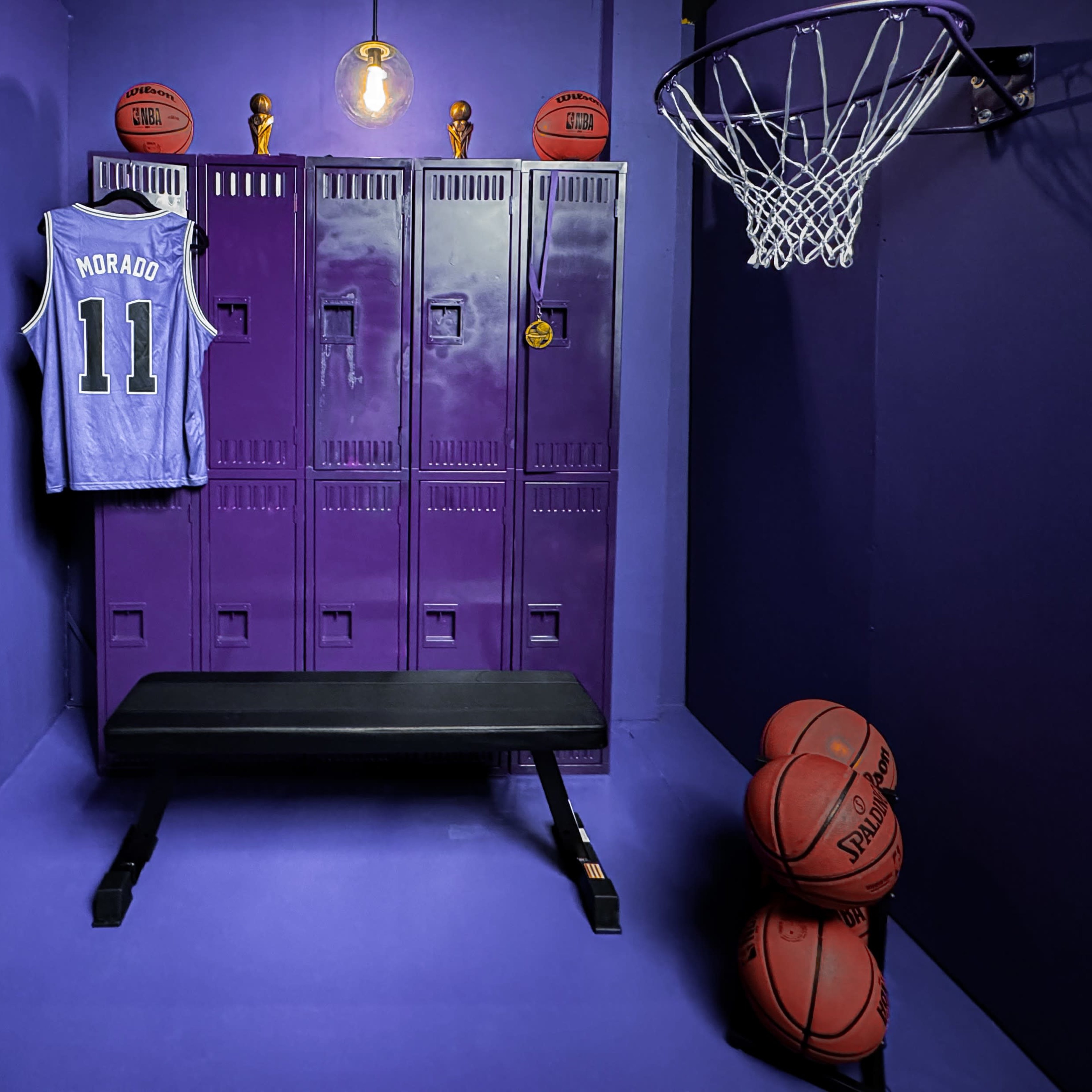 A purple locker room features a bench, five basketballs stacked in the corner, and a jersey hanging on a locker.