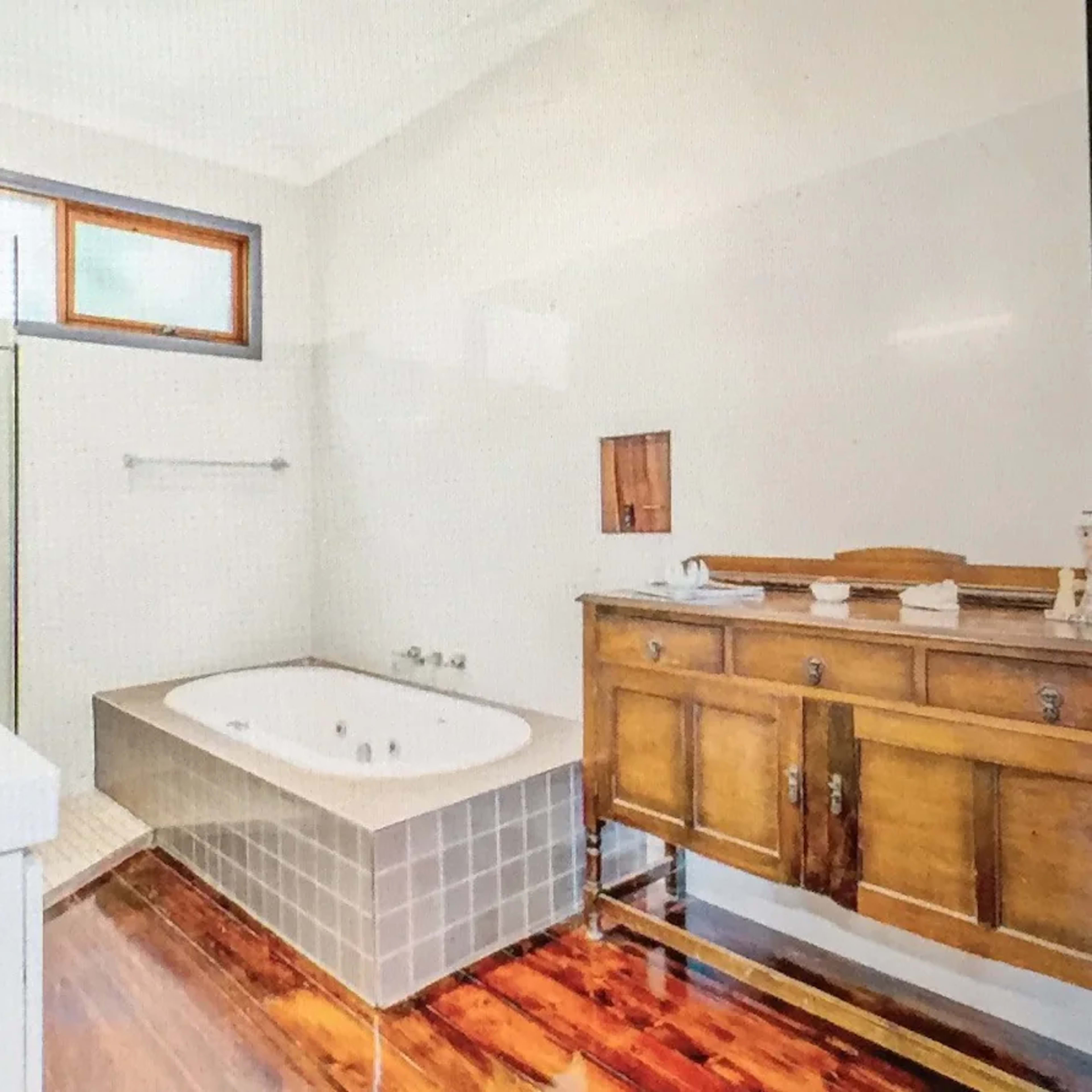 A modern bathroom featuring a jacuzzi tub, a wooden vanity, and a glass shower enclosure.