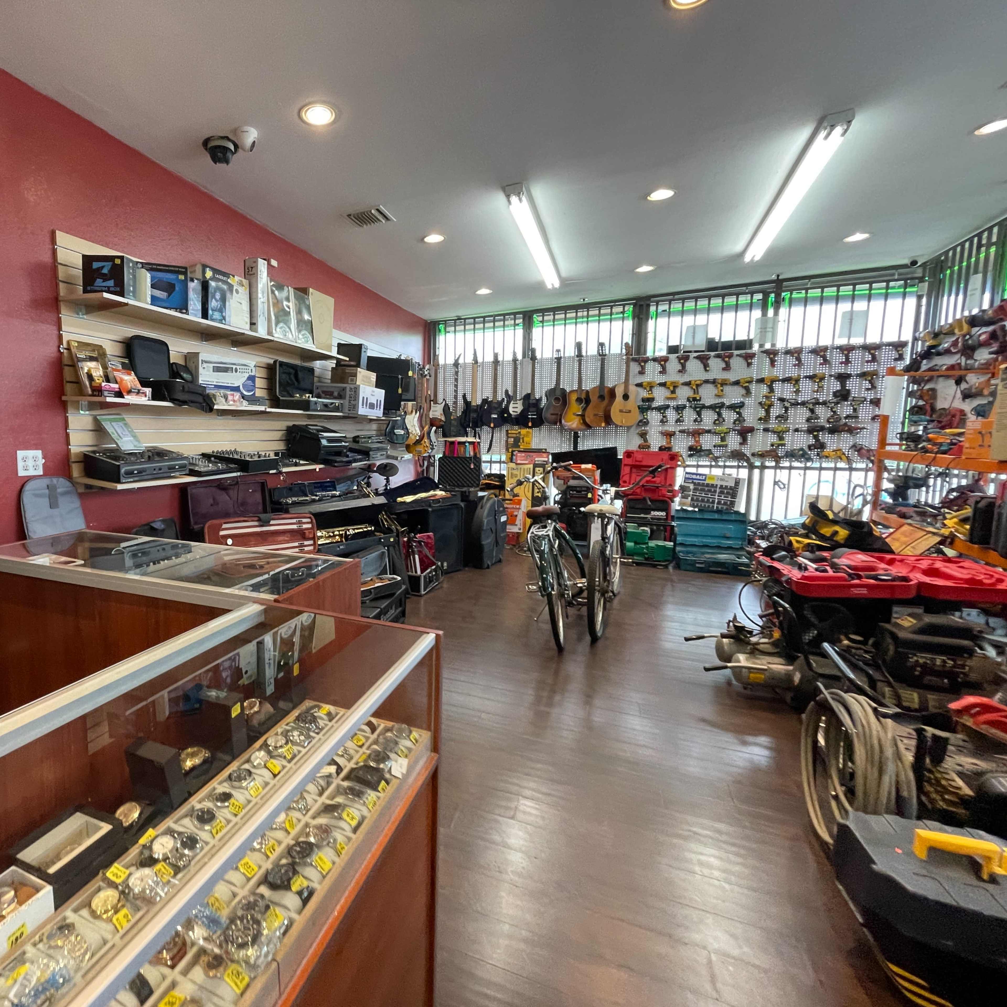 A retail store interior filled with various musical instruments, electronics, and bicycles on display.