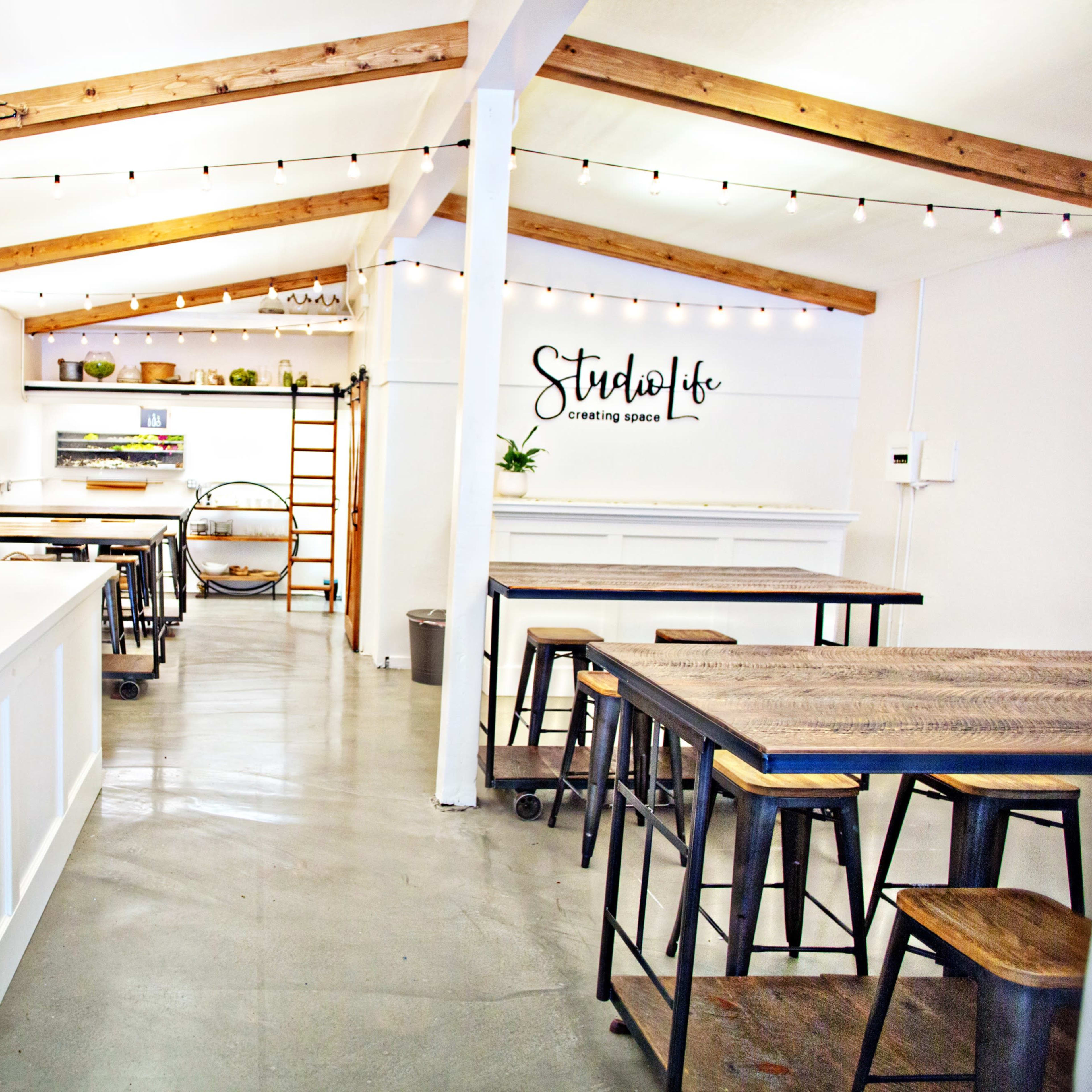 A bright, modern workspace with wooden beams, large tables, and a clean, minimalist design.