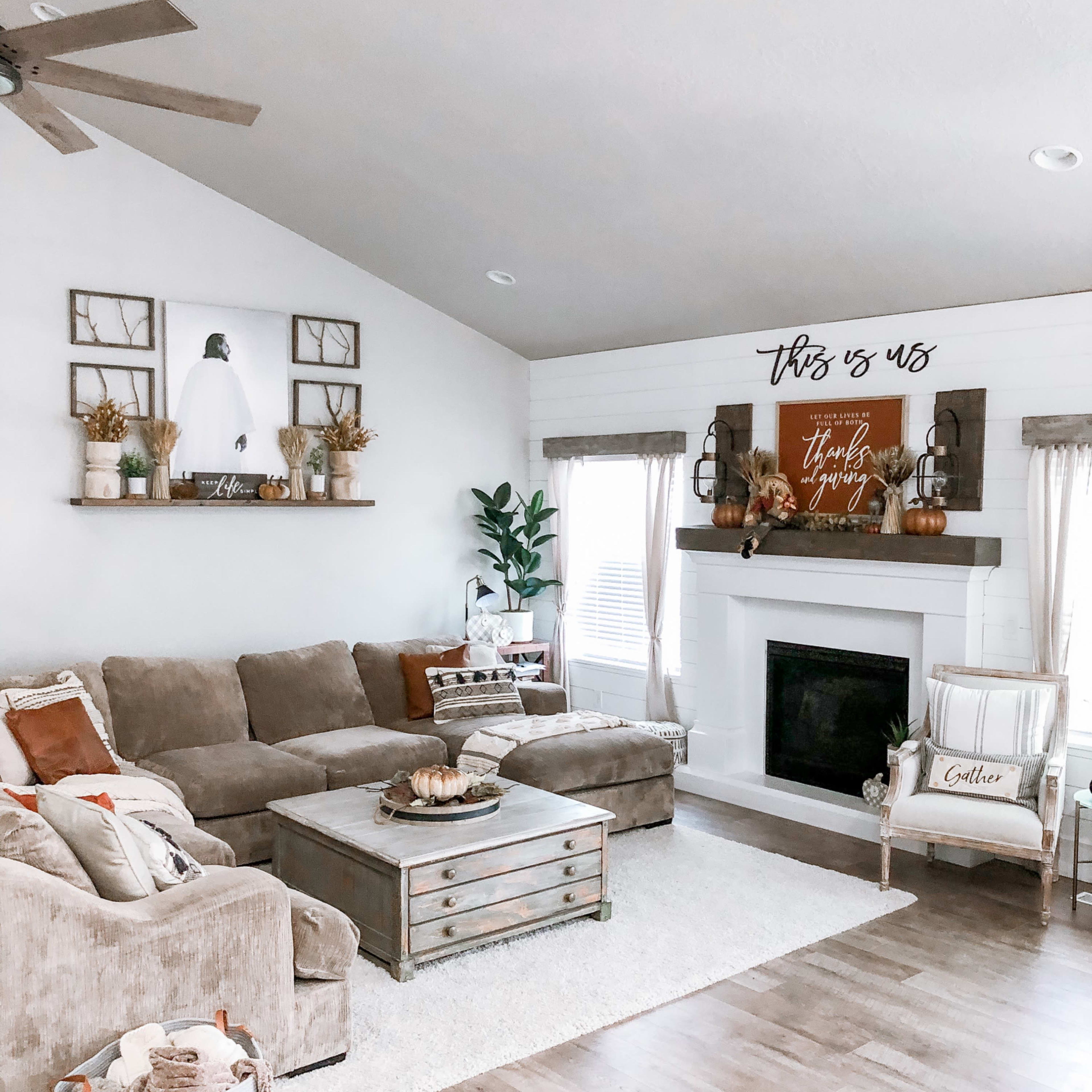 The living room features a large sectional sofa, a coffee table, and a fireplace decorated with seasonal decor and wall art.