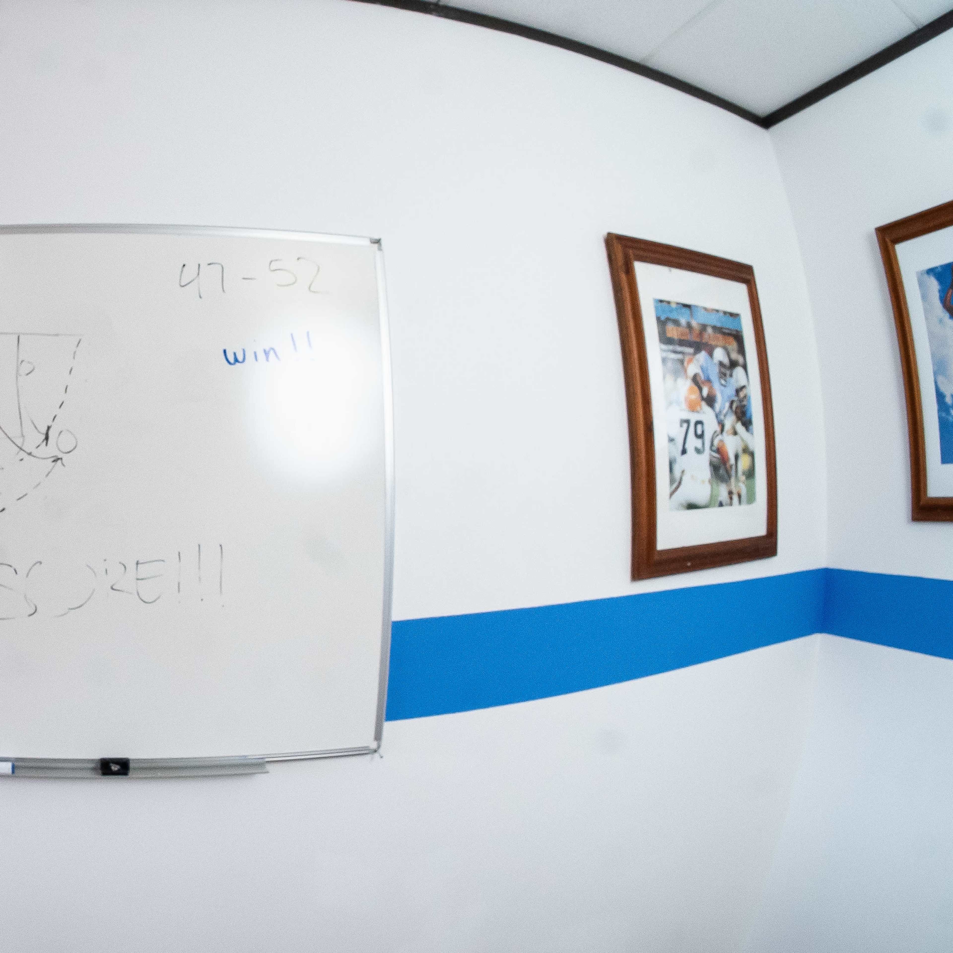 A whiteboard in a room displays a score of 97-52 with the word "WIN!!" and a drawn basket.