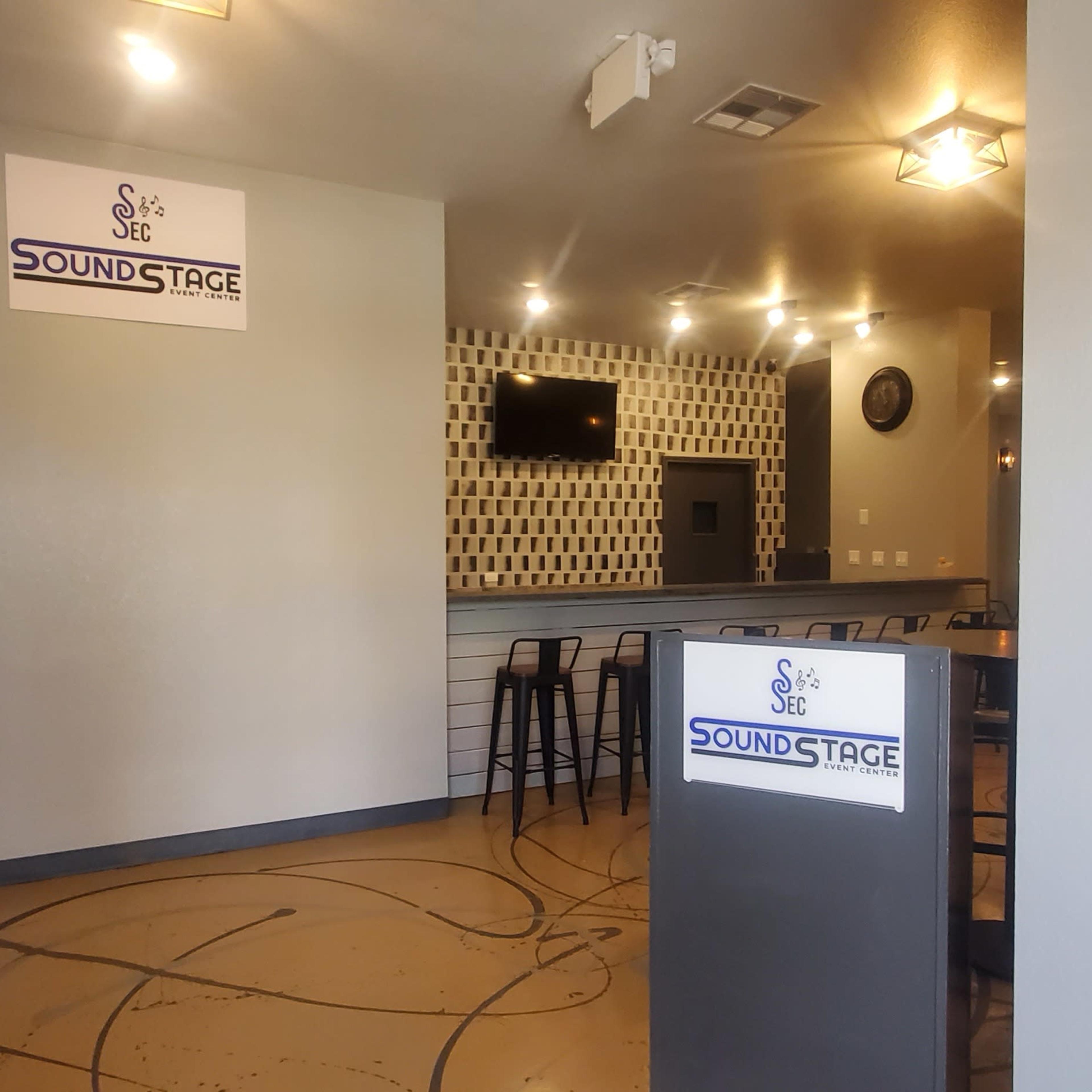 The interior of a venue named "Sound Stage," featuring a reception area with a front desk, a television on the wall, and a modern design.