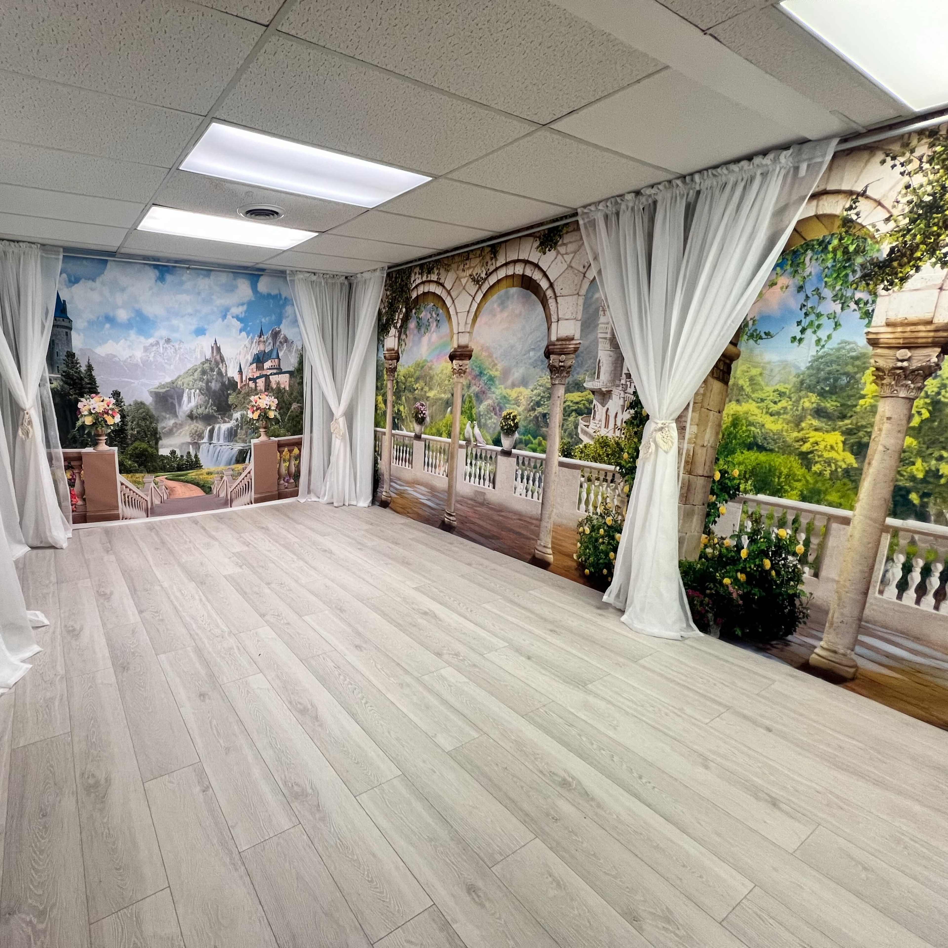 The room features mural wallpaper depicting a scenic landscape, complemented by floor-to-ceiling curtains and light-colored flooring.