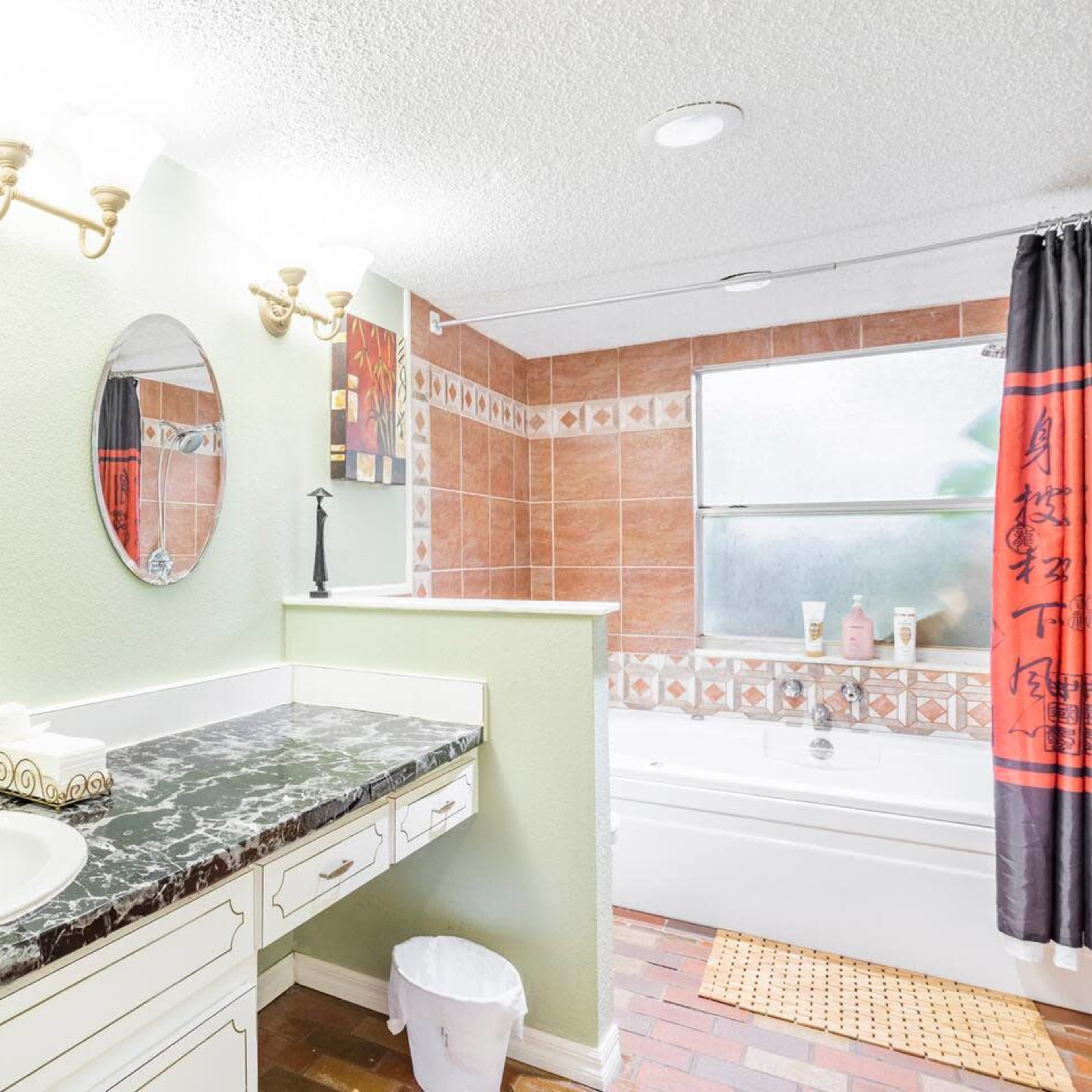 A bathroom with a double vanity featuring two mirrors, a bathtub, and tile accents on the walls and floor.