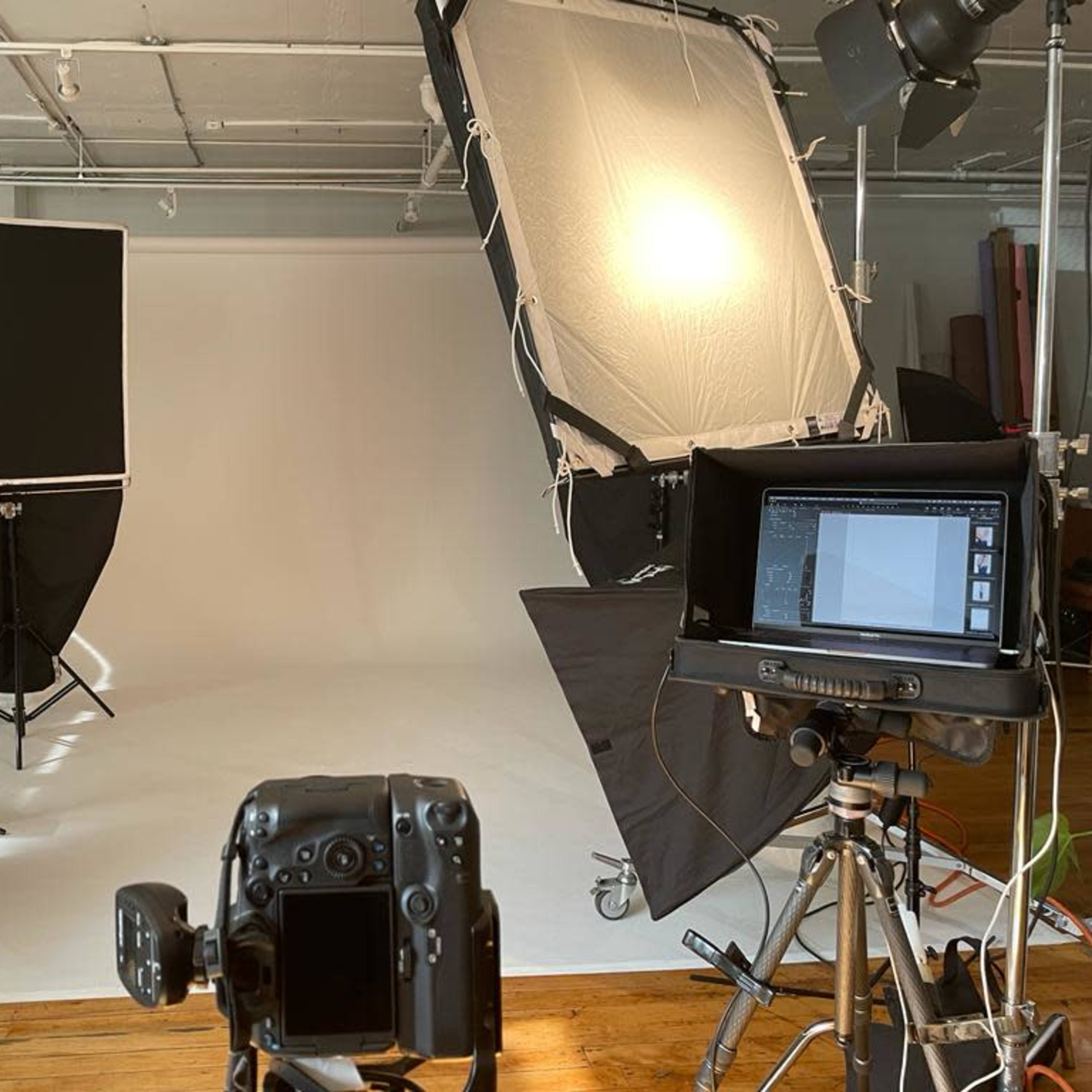 A photography studio is set up with lights, backdrops, and camera equipment on display.