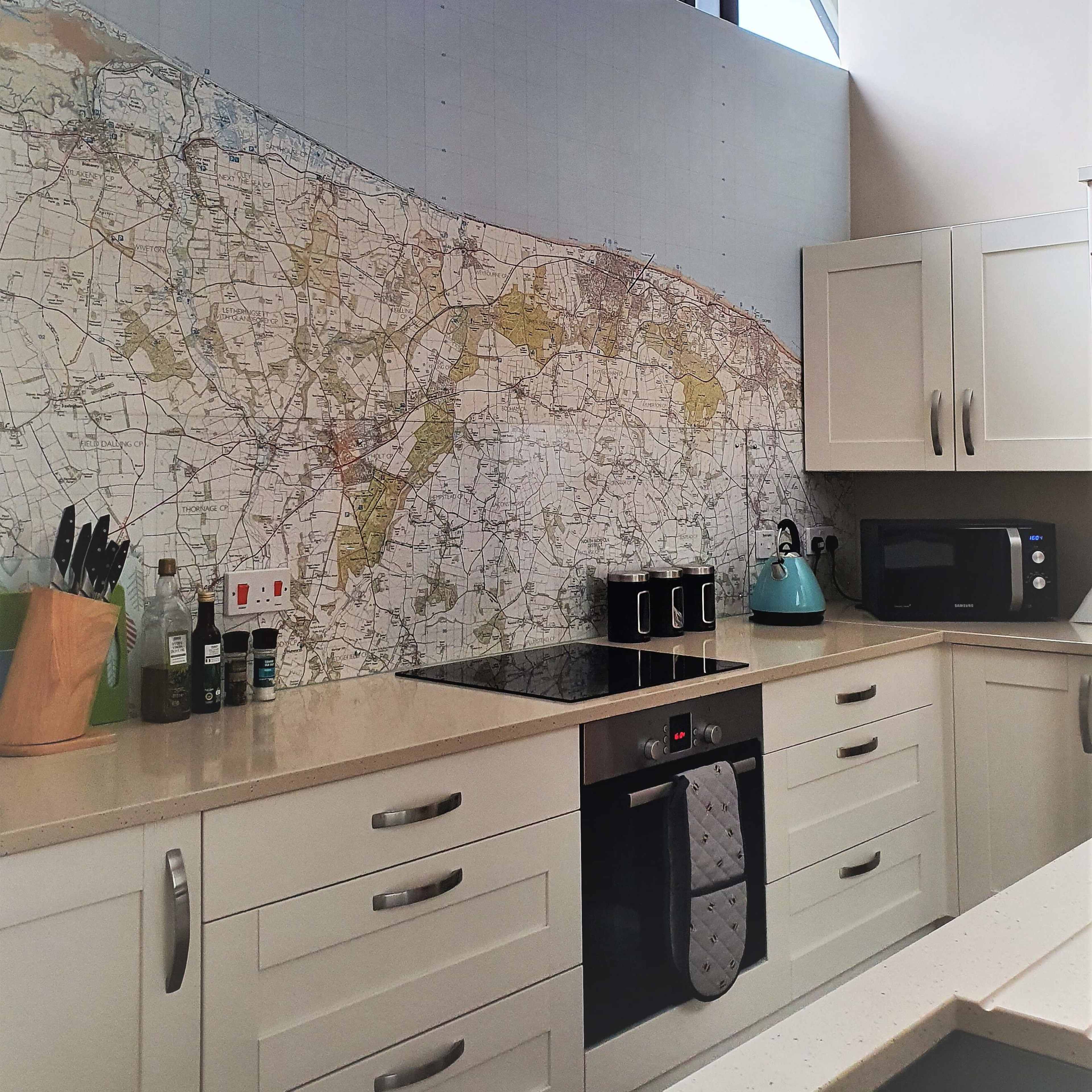 The kitchen features a large wall mural of a detailed map, with modern cabinets and appliances arranged below it.