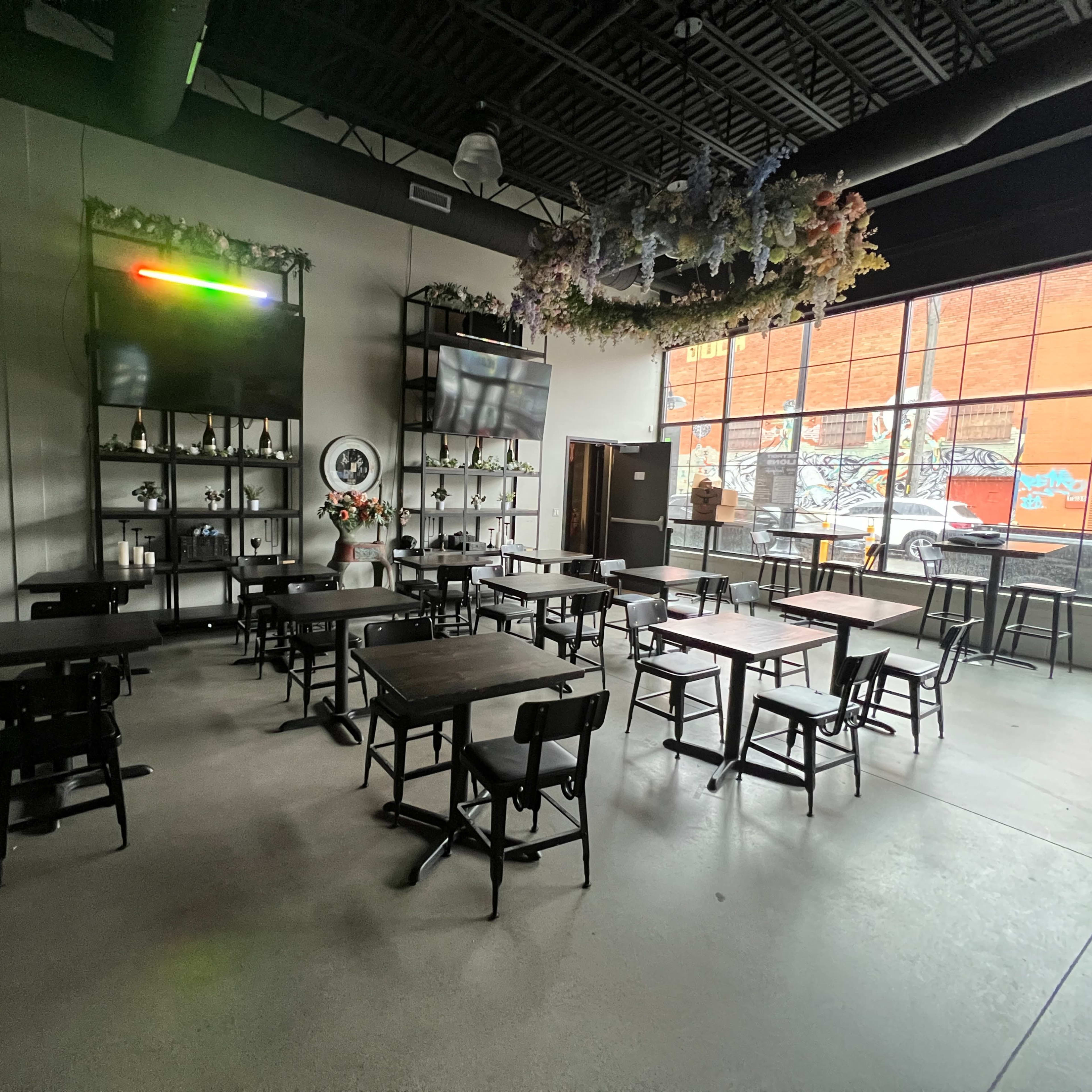 An empty modern cafe with multiple tables arranged and decoration on the walls.