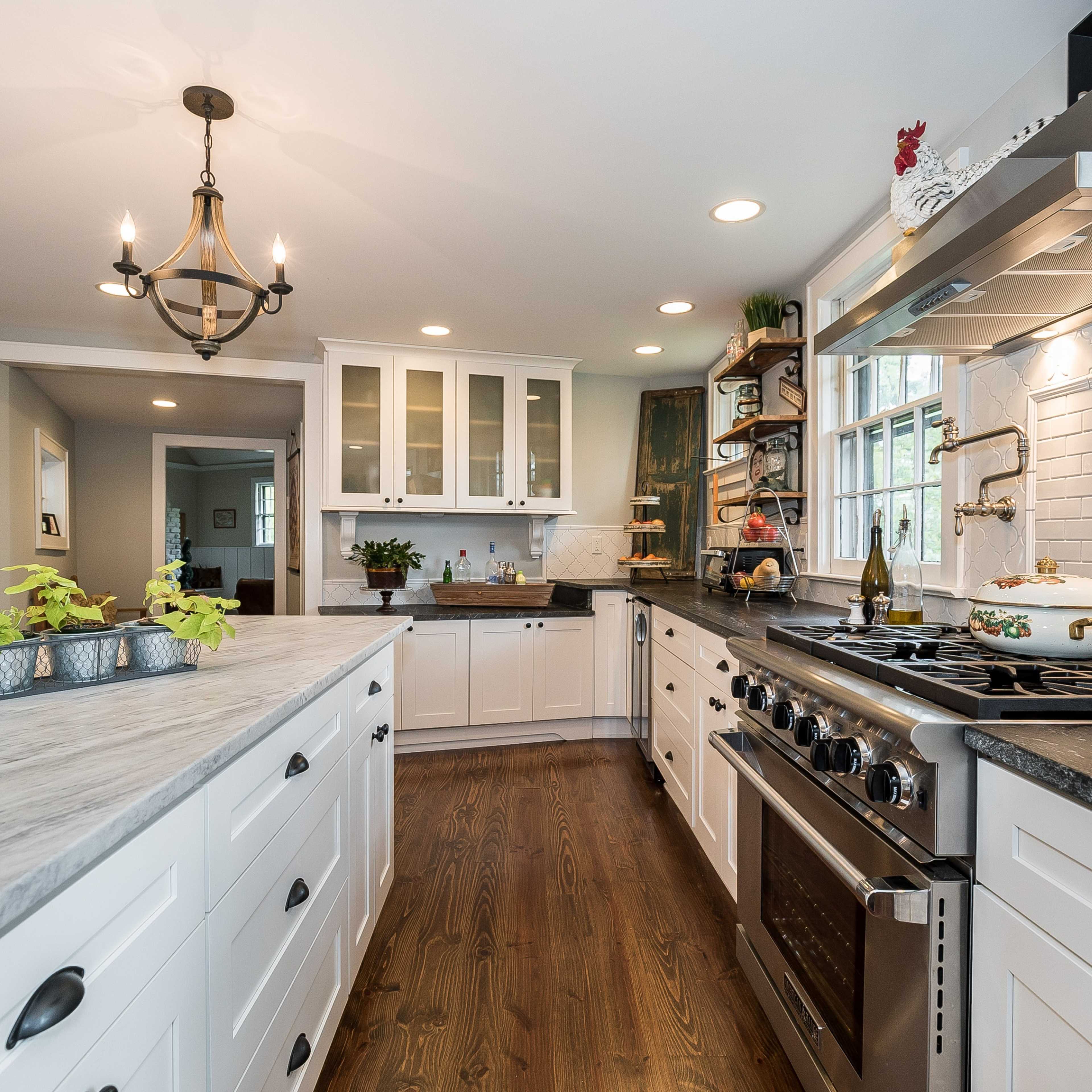 The kitchen features white cabinetry, granite countertops, and modern appliances arranged in an open layout with natural light.