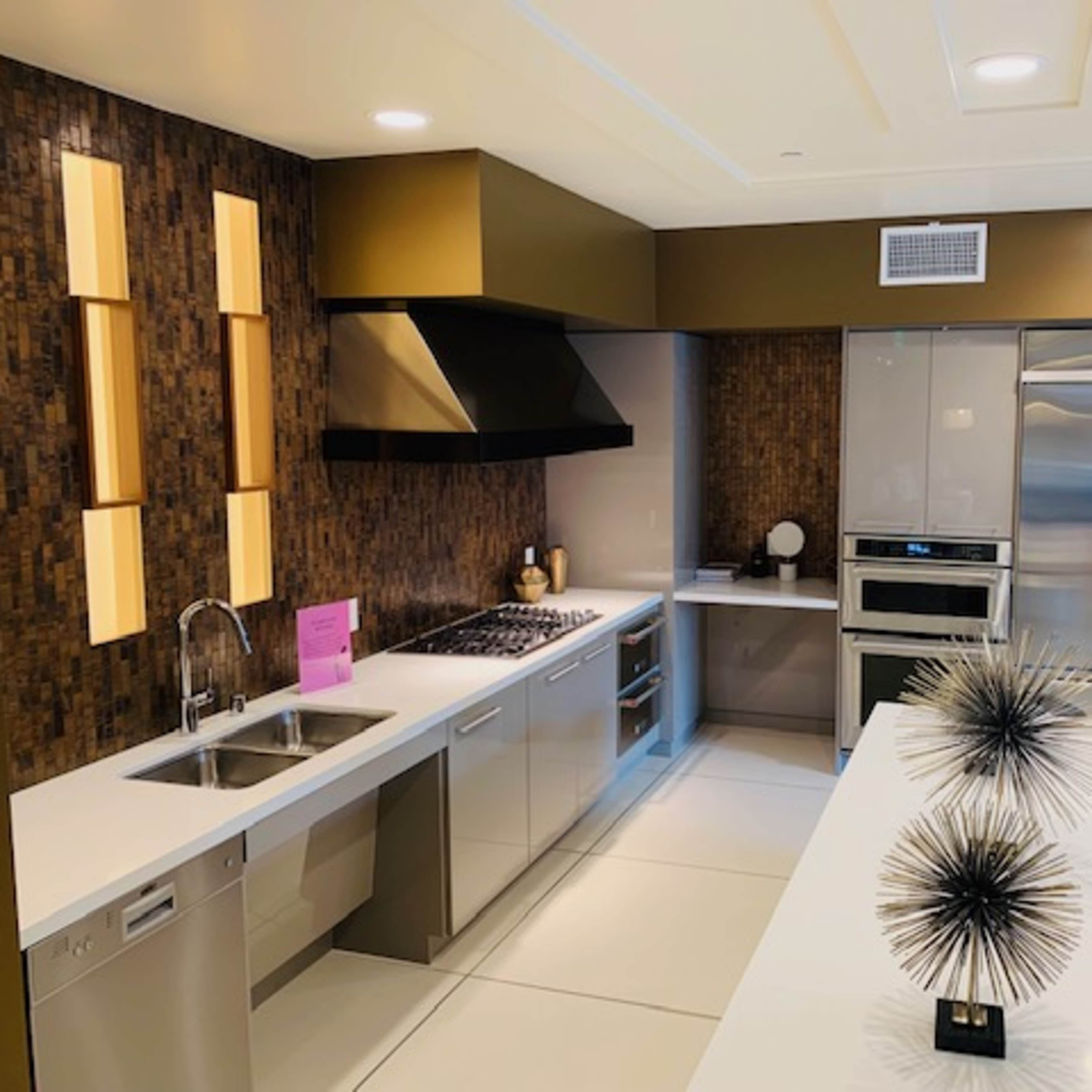 A modern kitchen featuring stainless steel appliances, sleek cabinetry, and a dining table with decorative centerpieces.
