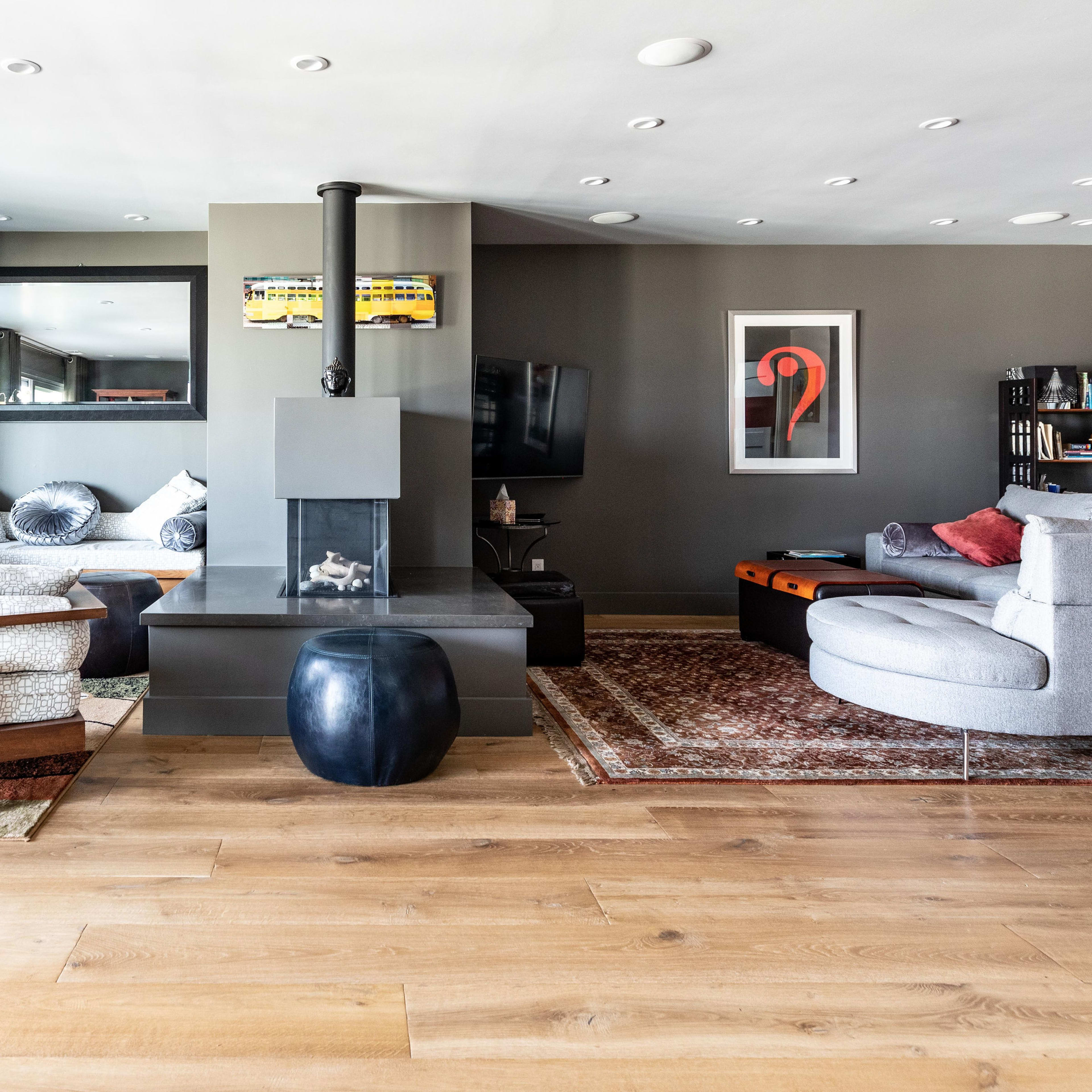 A modern living room featuring a fireplace, comfortable seating areas, and an open layout with wooden flooring.