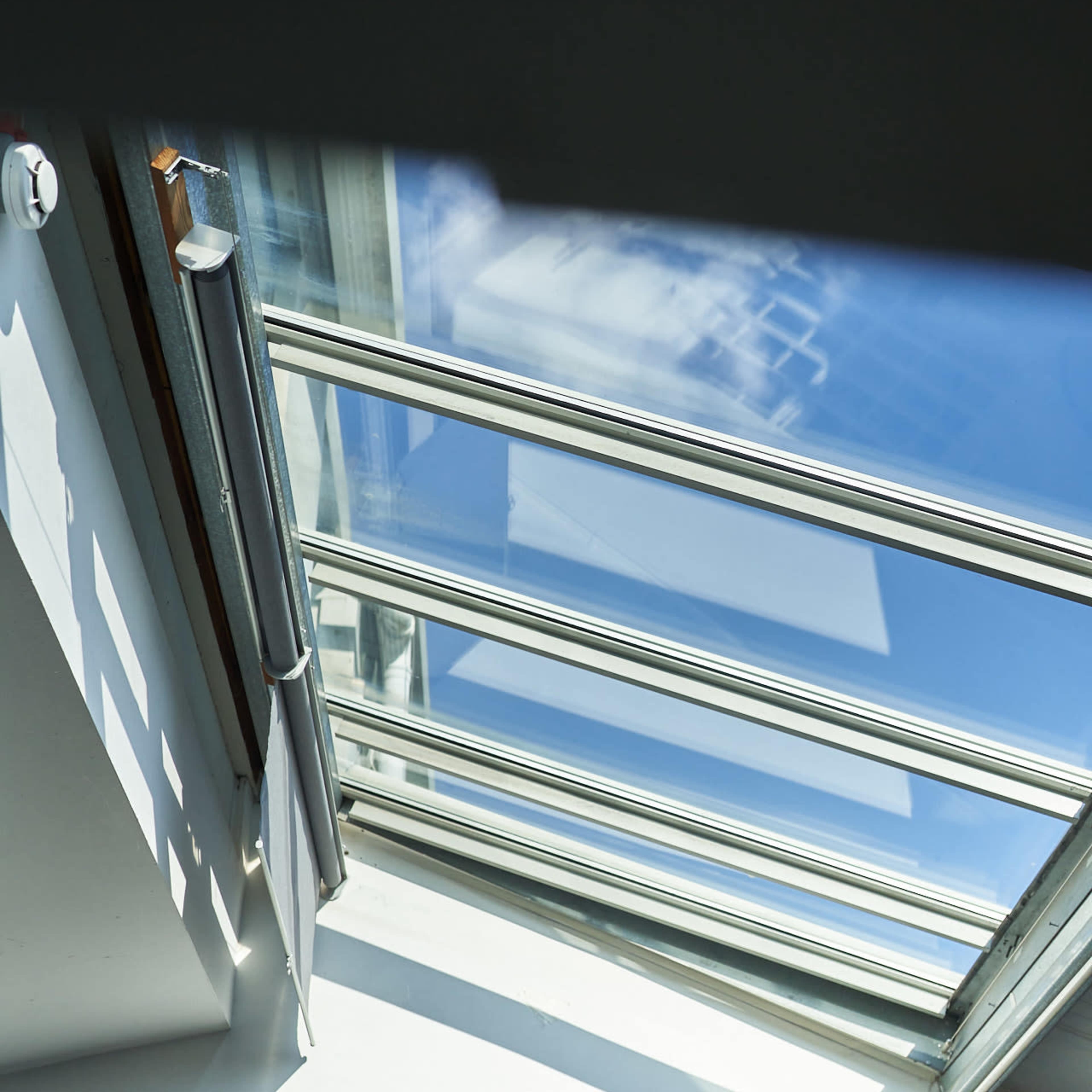 A skylight in a modern room, allowing sunlight to illuminate the white walls below.