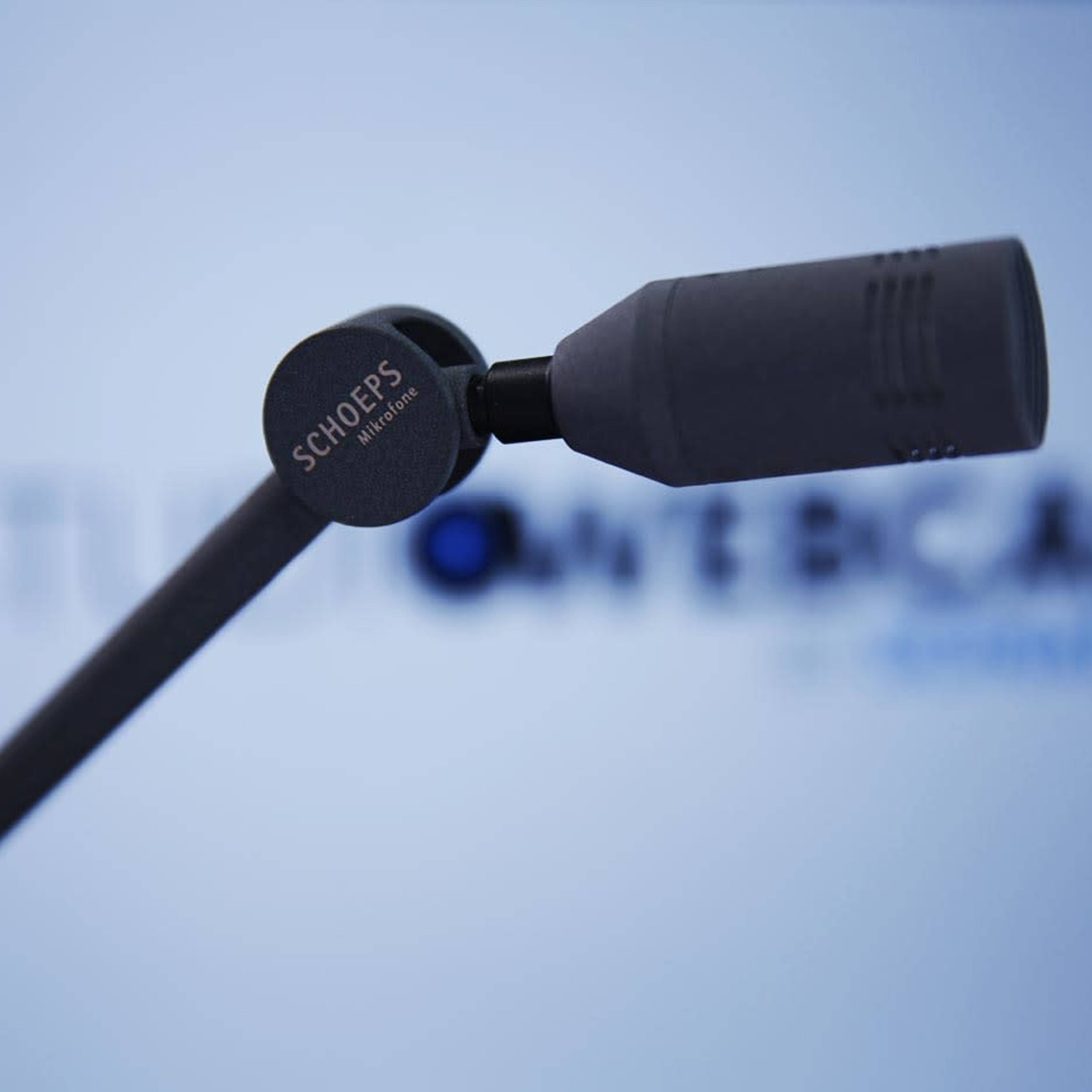 A microphone is positioned in front of a blurred background displaying the text "STUDIO OVERCAST."