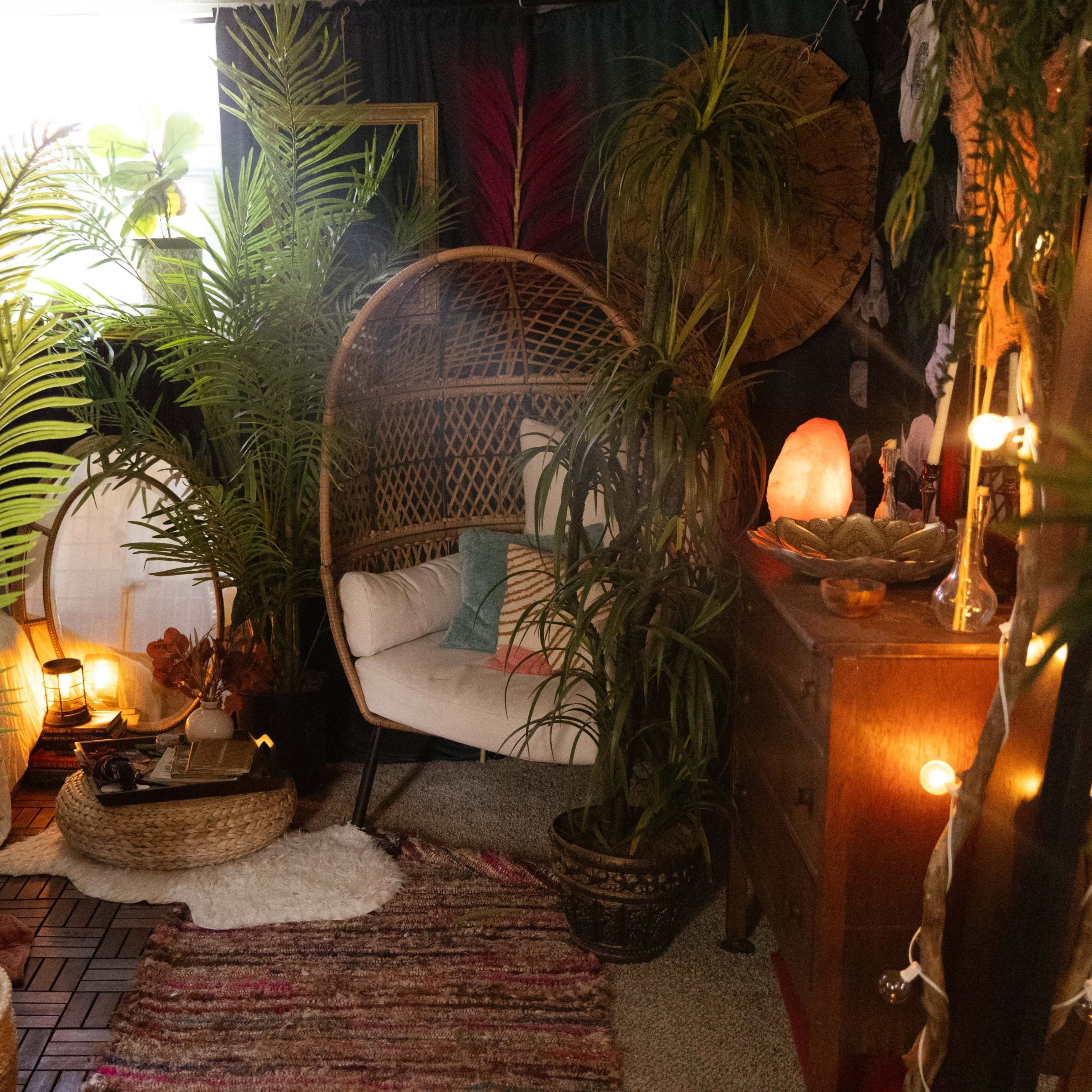 A cozy indoor space filled with various potted plants, a rattan chair, a wooden dresser, and warm string lights.