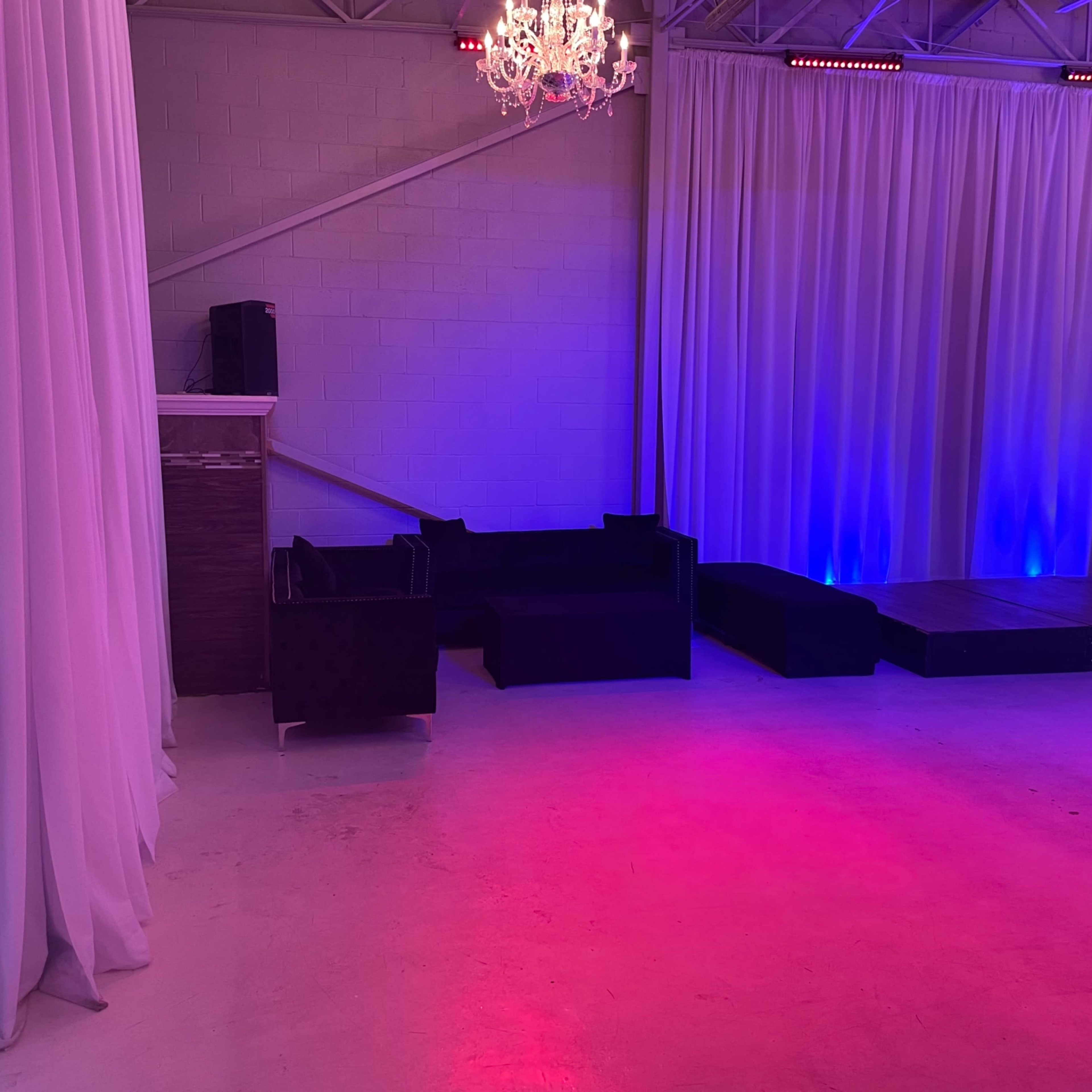 An event space with a stage, seating area, and decorative lighting.