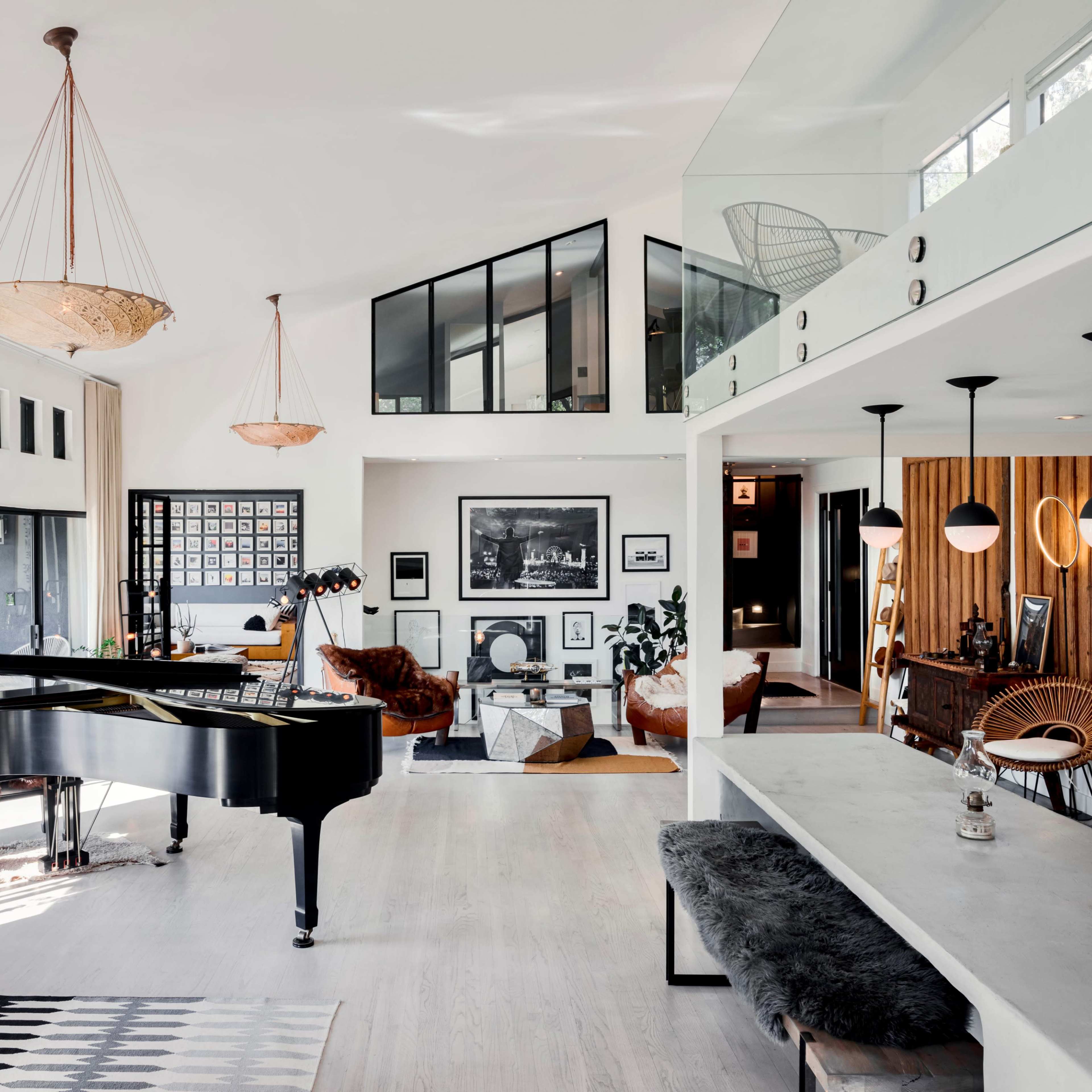 A modern, spacious living area featuring a grand piano, contemporary furniture, and a mix of textures and materials in the decor.