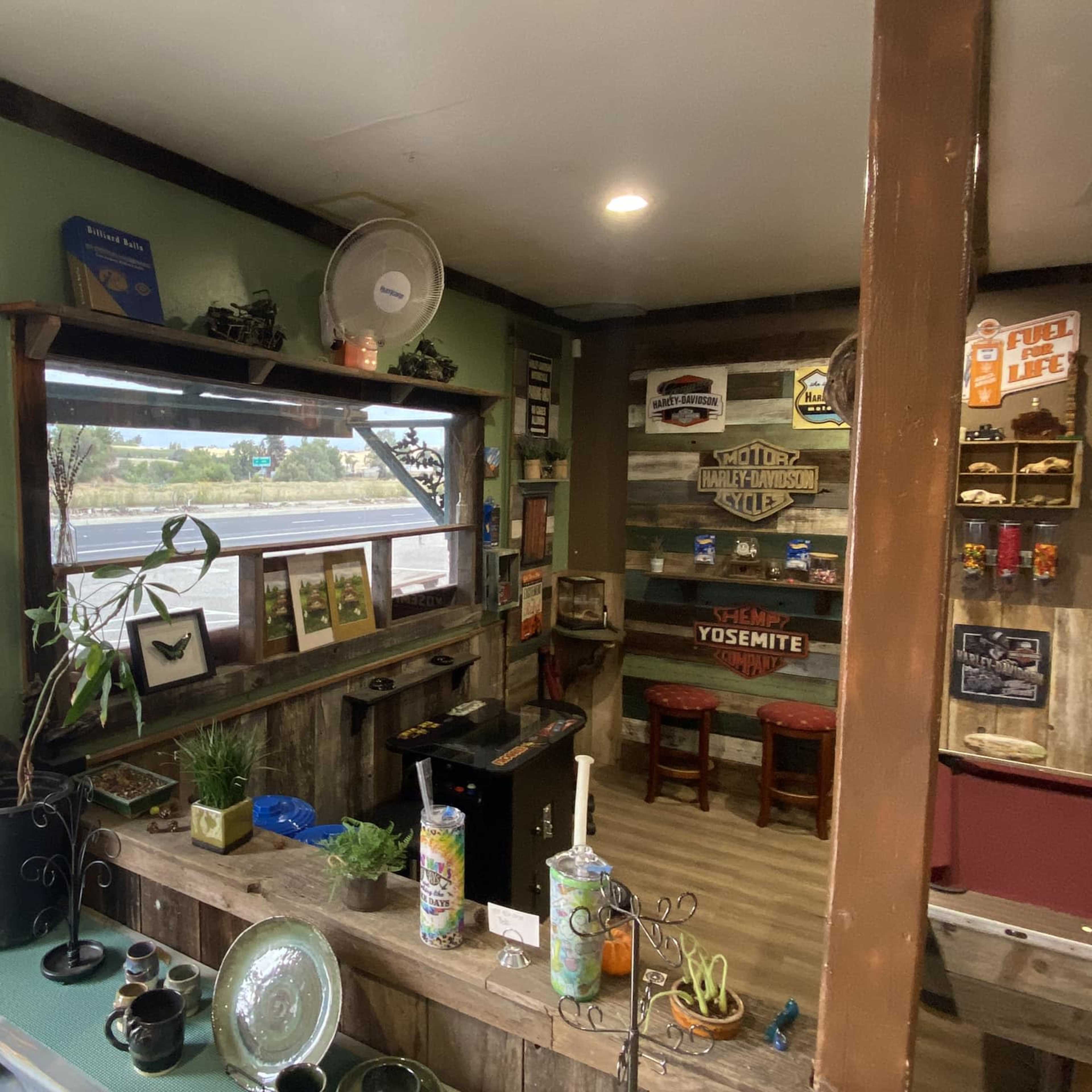 The scene shows a small interior space with decorated walls, a counter, and a view of a window facing a parking lot.