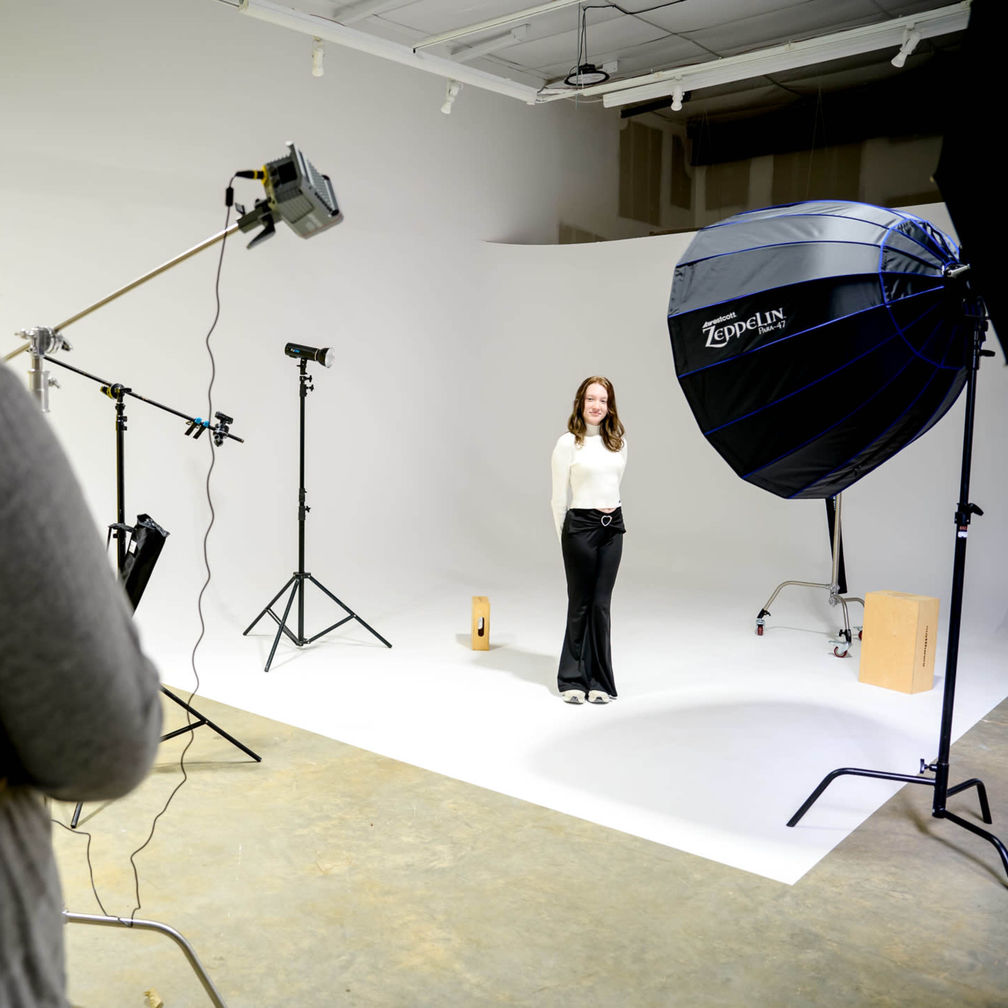 A photography studio equipped with various lighting setups, backdrops, and photography equipment.