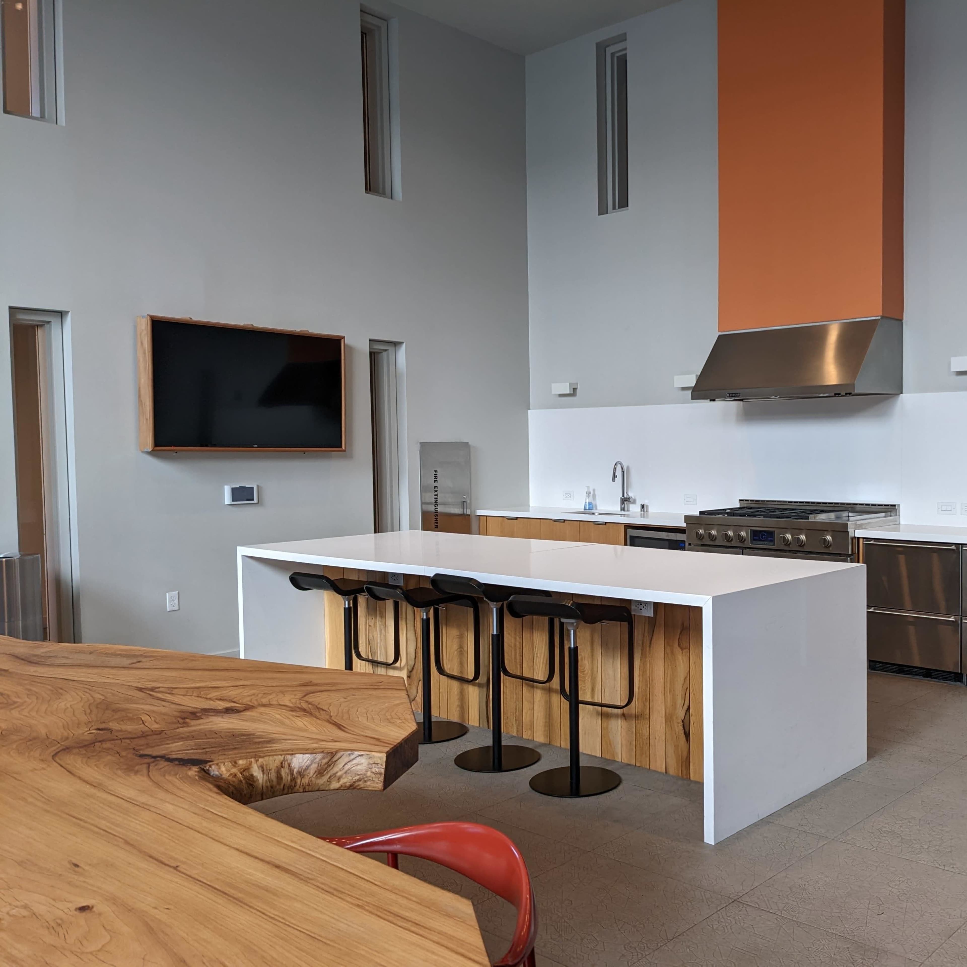 A modern kitchen with a large island, stainless steel appliances, and a minimalist design.