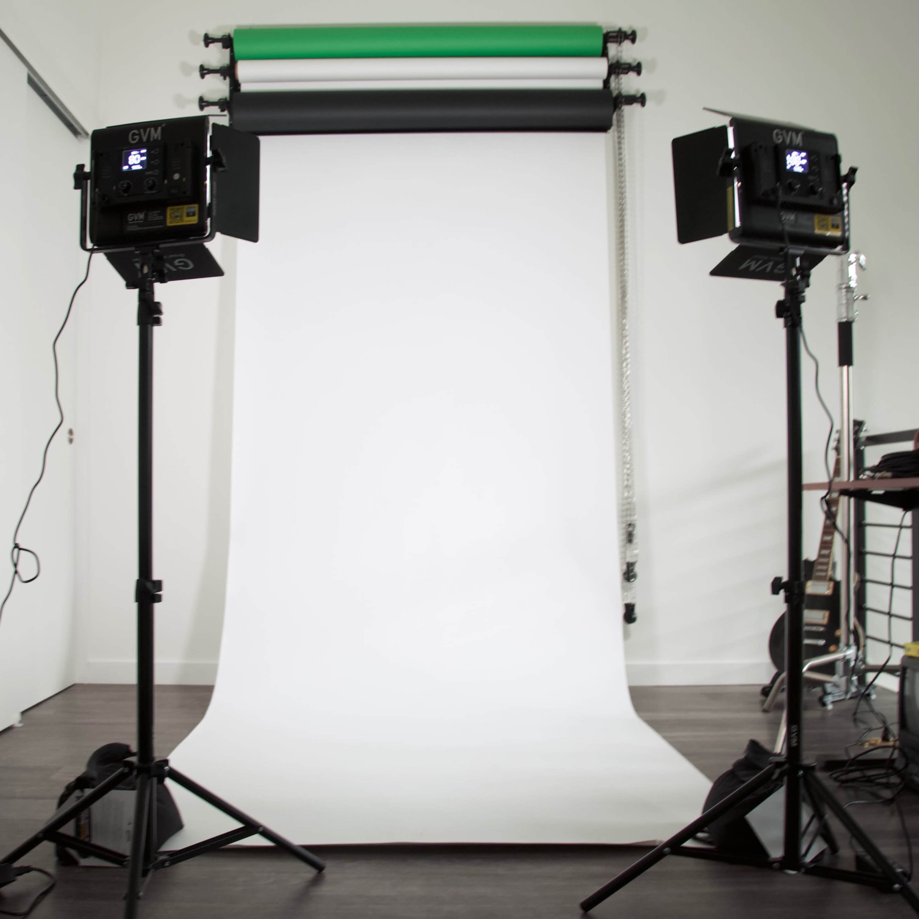 A photography studio setup with two lights on stands facing a white backdrop.