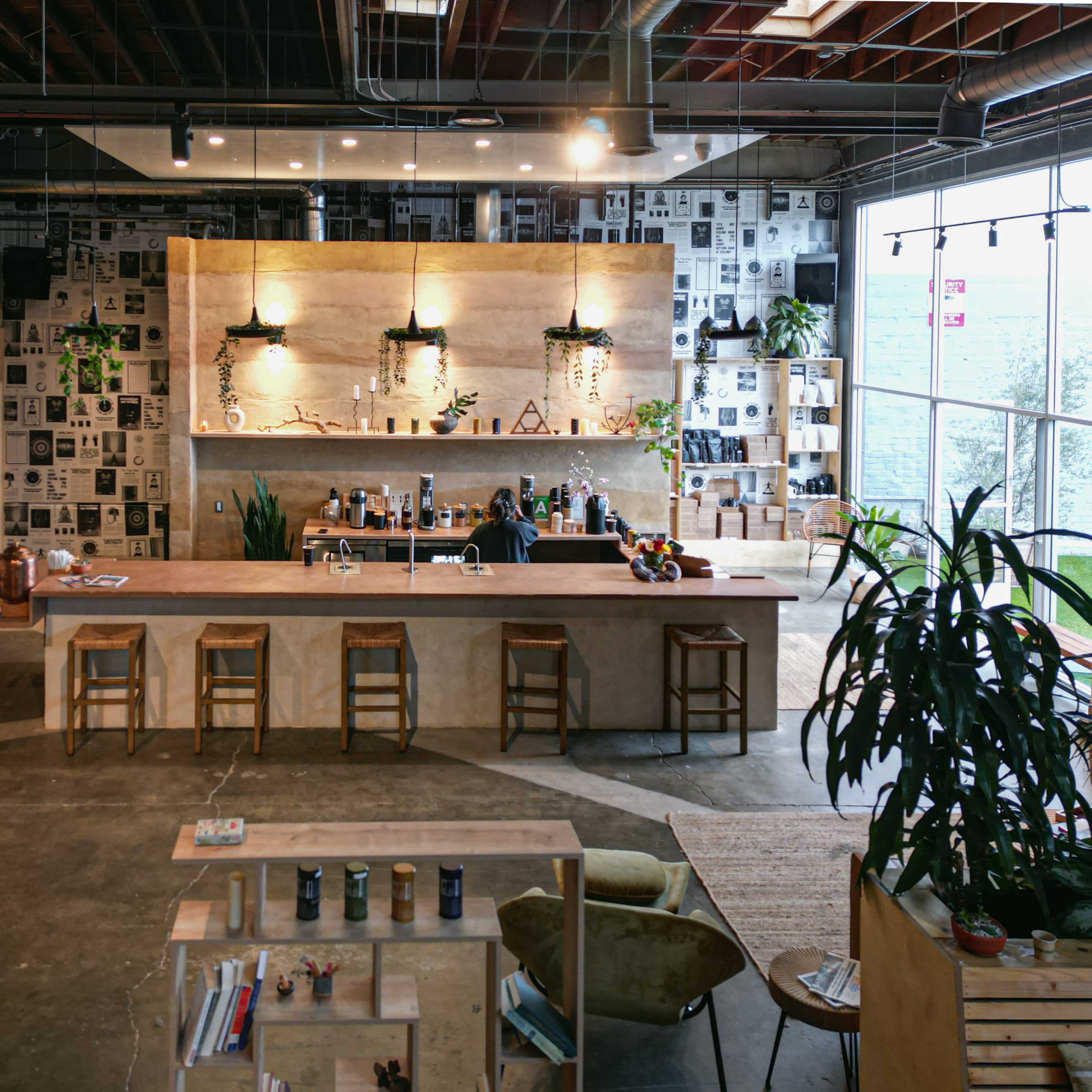 A modern coffee shop interior with a wooden counter, bar stools, and walls decorated with black-and-white photographs.