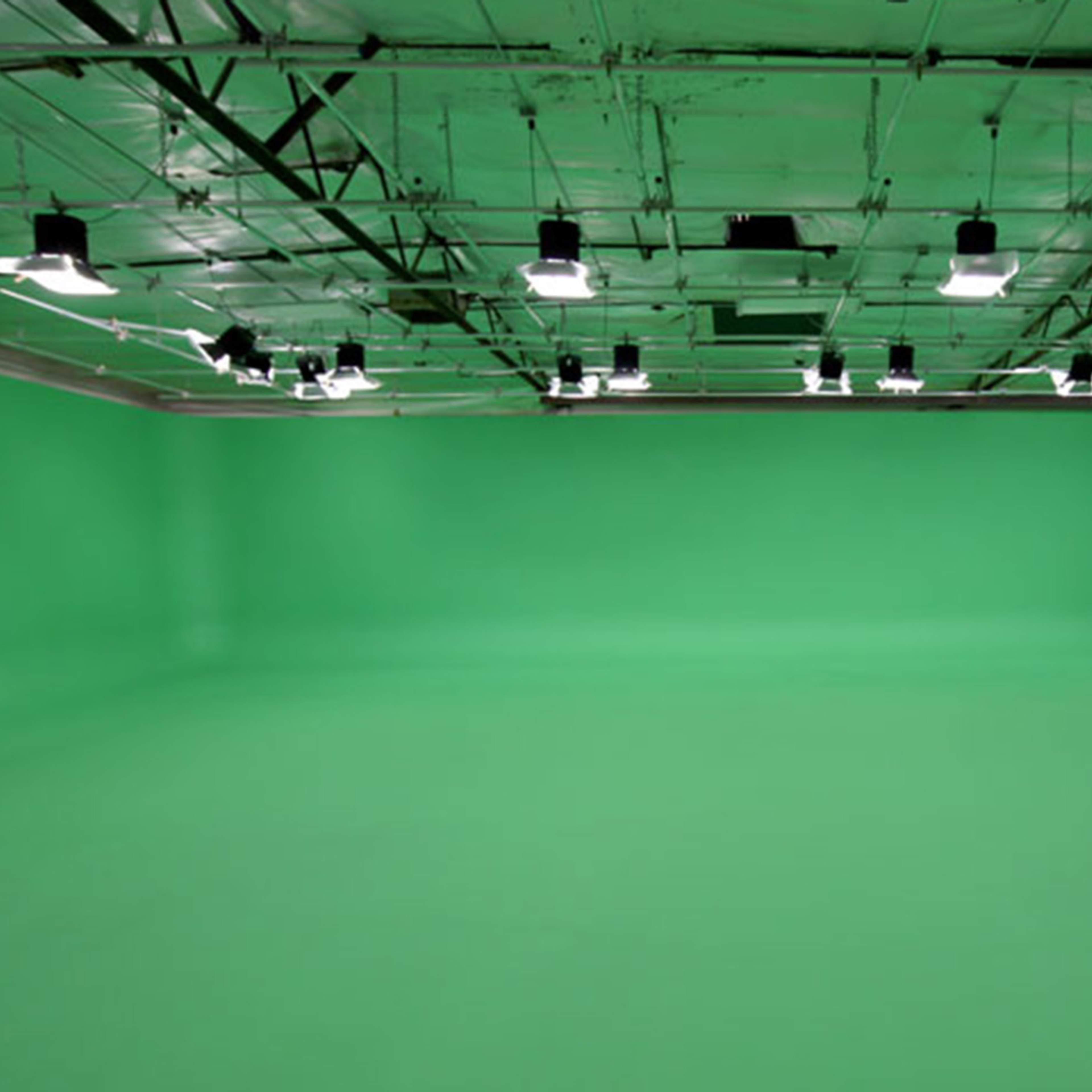 A green screen studio with evenly spaced lighting fixtures on the ceiling.