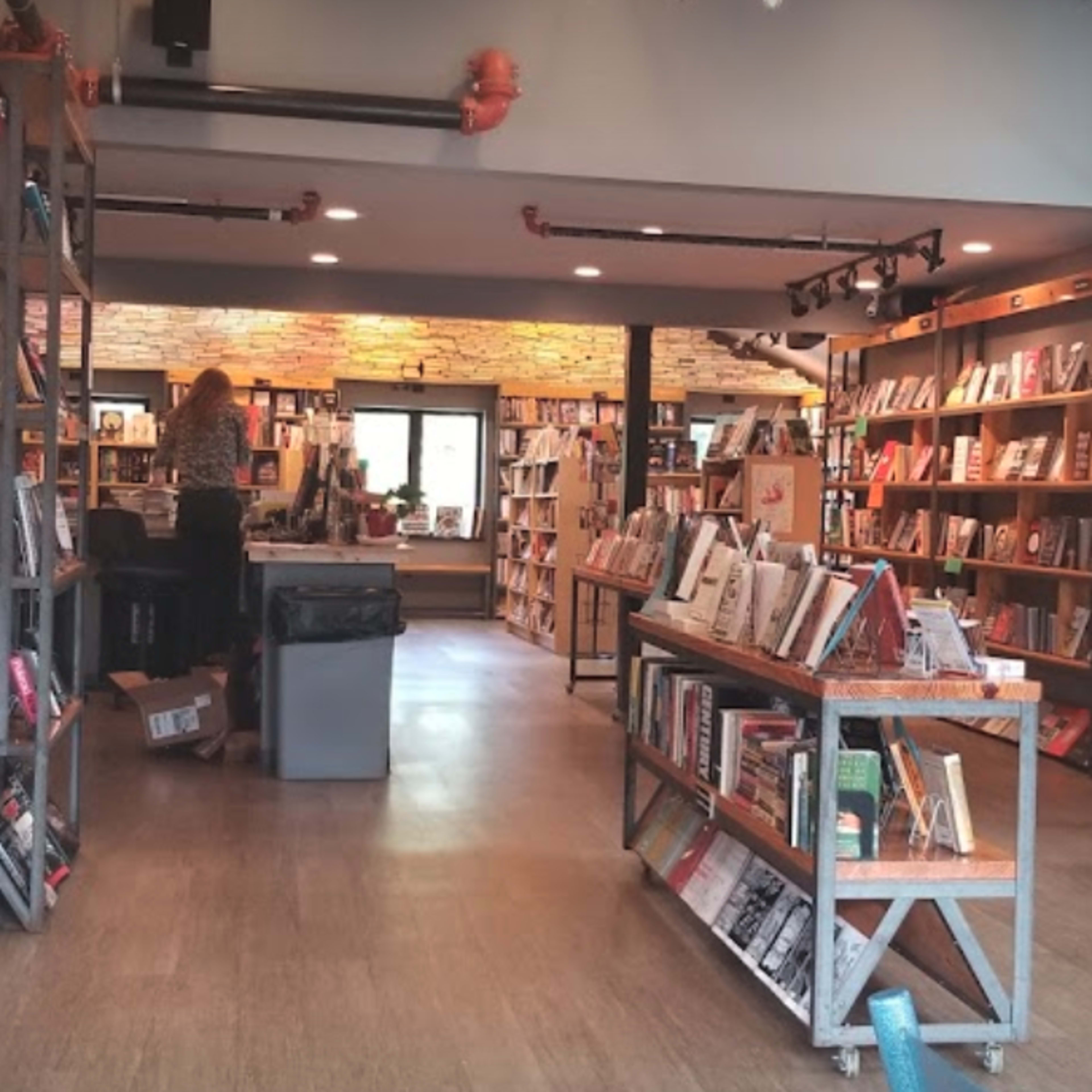 A well-organized bookstore with shelves of books lining the walls and a seating area in the center.