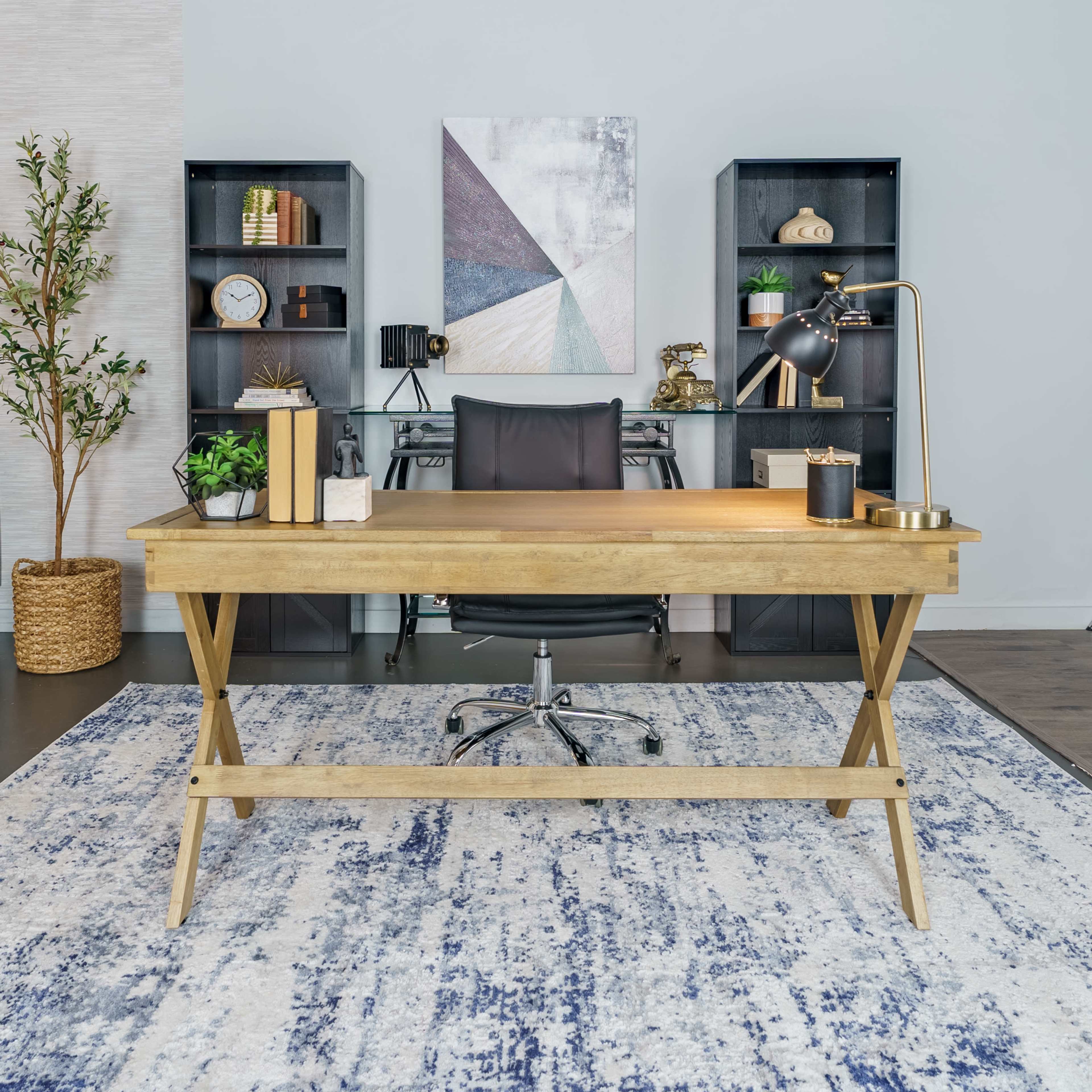 A wooden desk with a chair is positioned in a modern office space featuring bookshelves and a decorative rug.