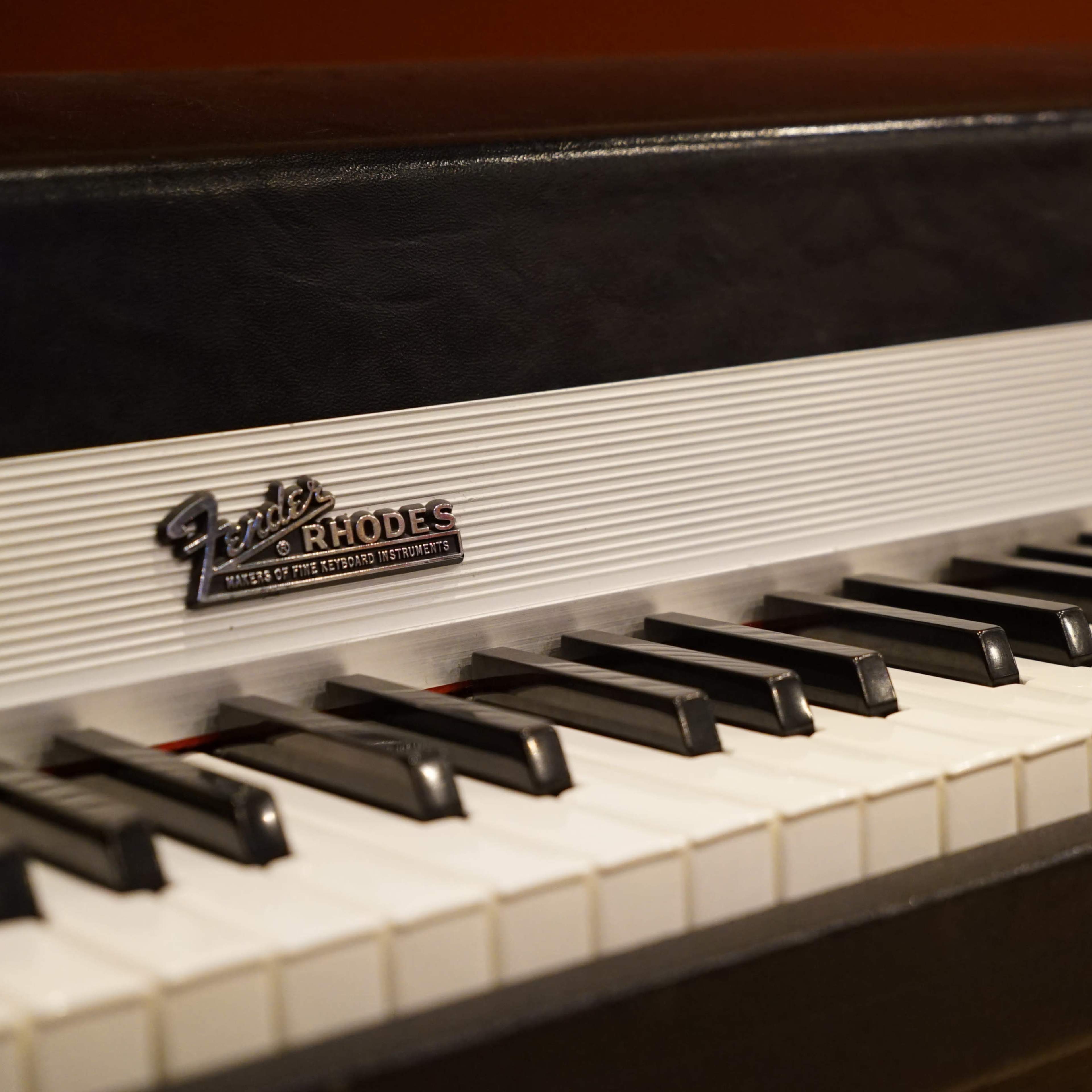 The keyboard of a Fender Rhodes electric piano with black and white keys and a textured surface.