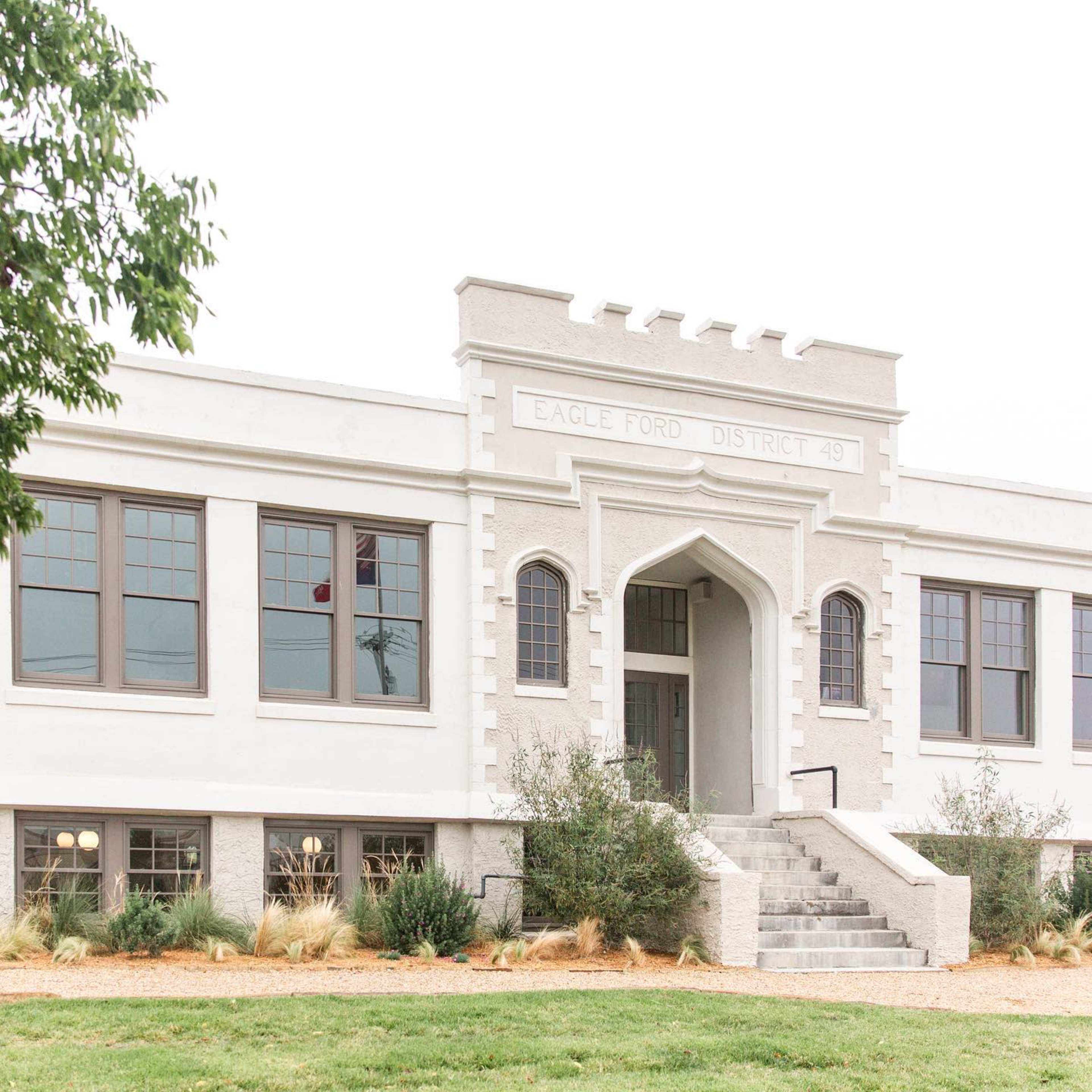 The exterior of a historic building labeled "Eagle Ford District 49" with an arched entrance and decorative architectural features.
