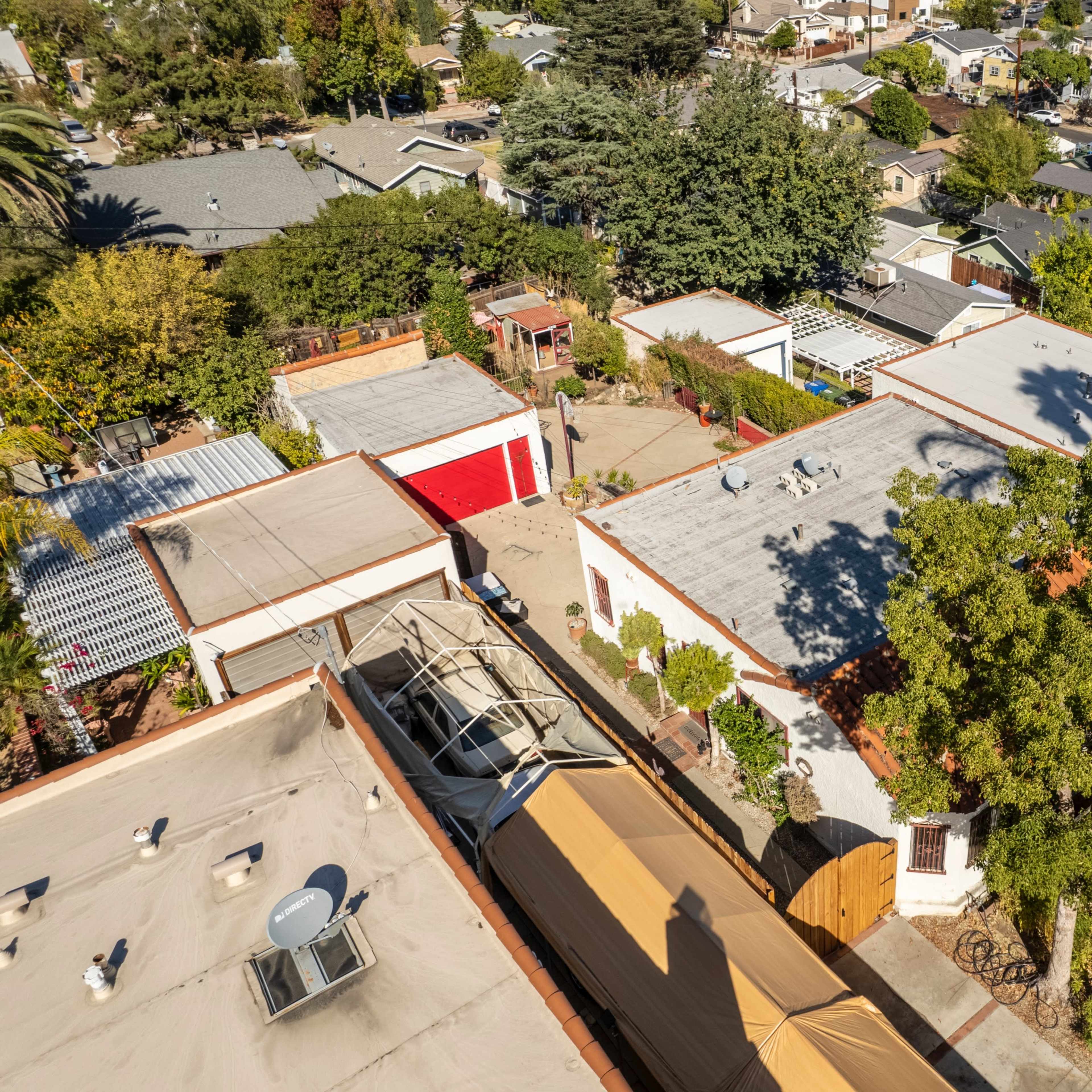 An aerial view of a suburban neighborhood with a mixture of residential buildings, roofs, and greenery.
