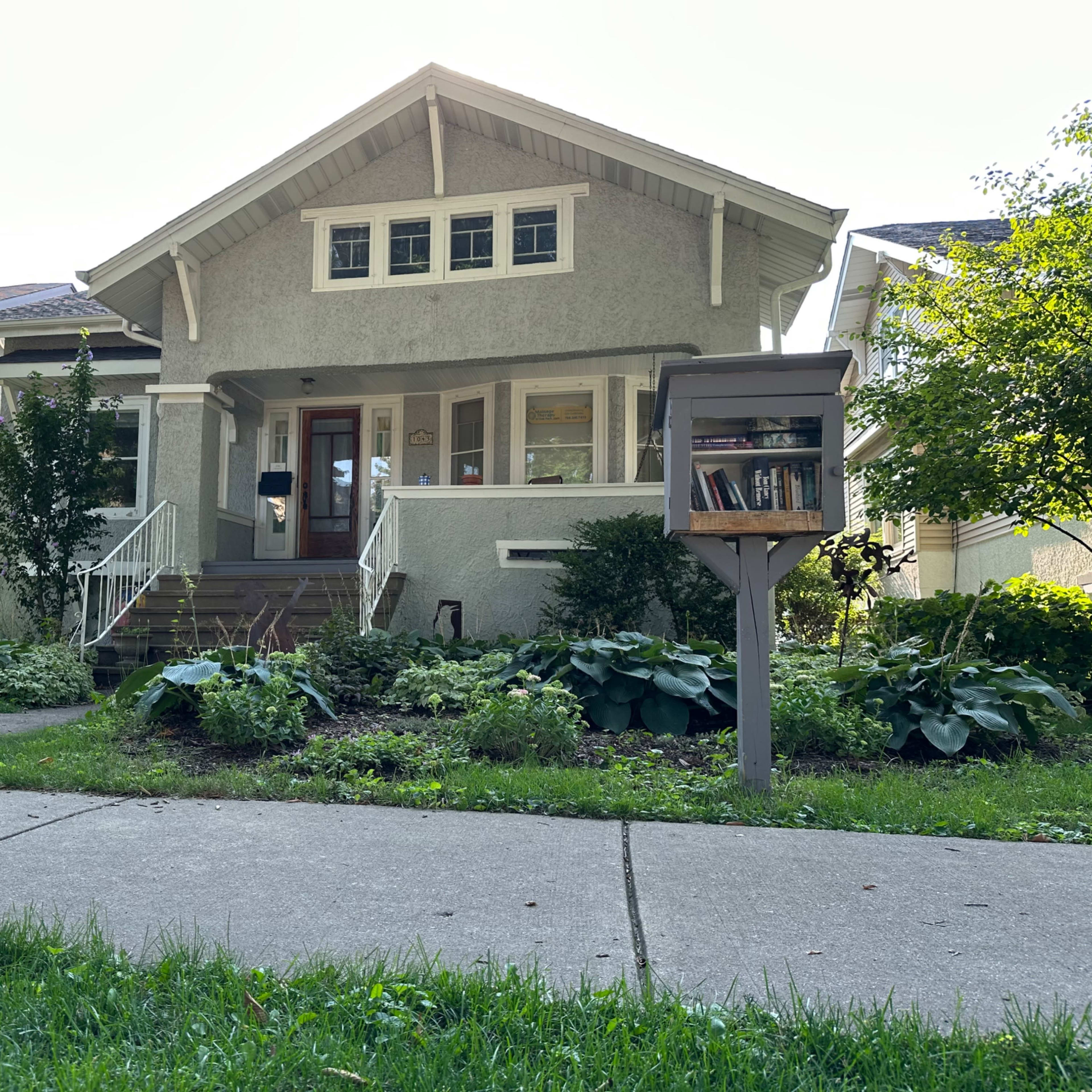 A single-family house with a covered front porch, surrounded by well-maintained landscaping and a mailbox at the edge of the lawn.