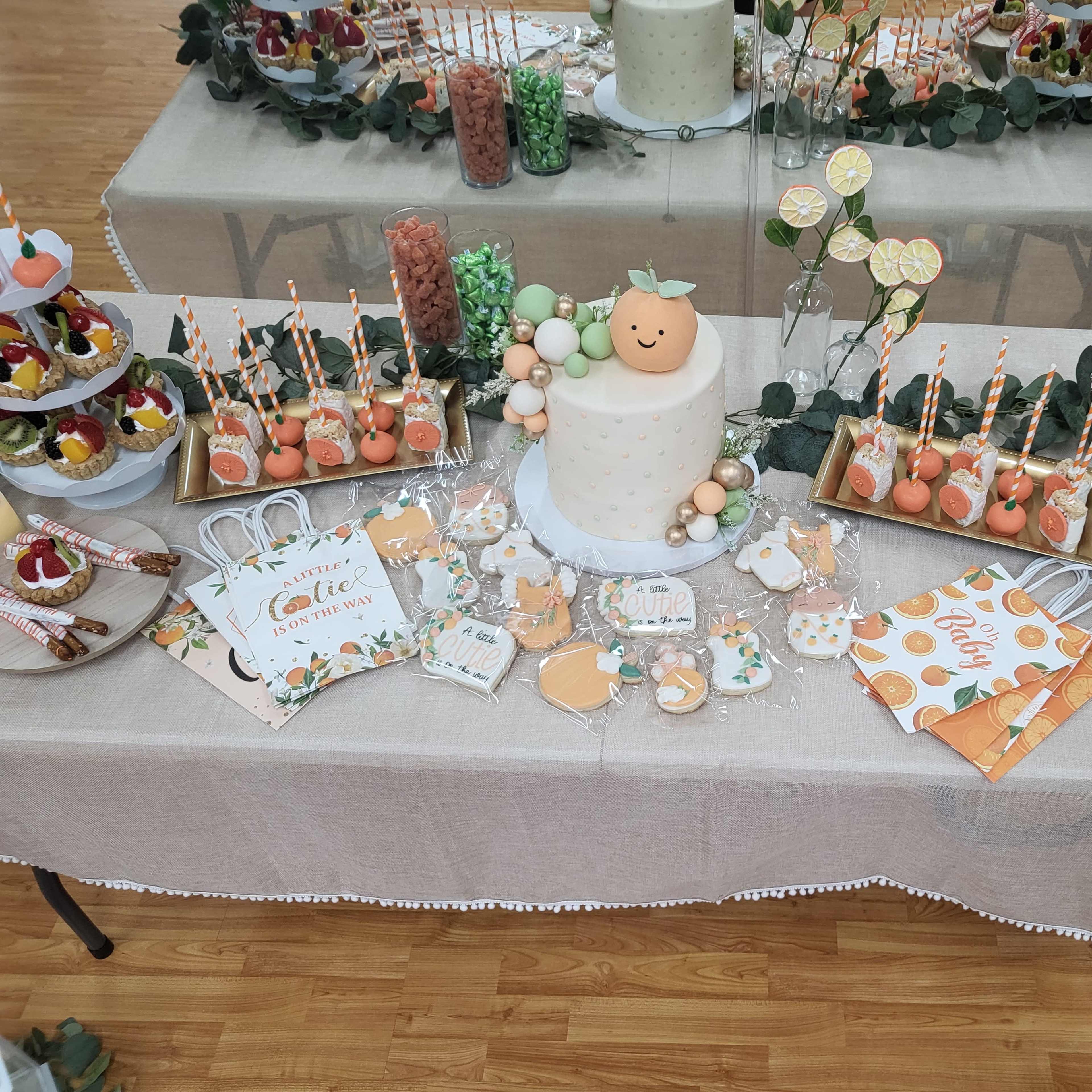 A dessert table adorned with a variety of treats, including a decorated cake, cupcakes, candies, and themed decorations, all arranged on a beige tablecloth.