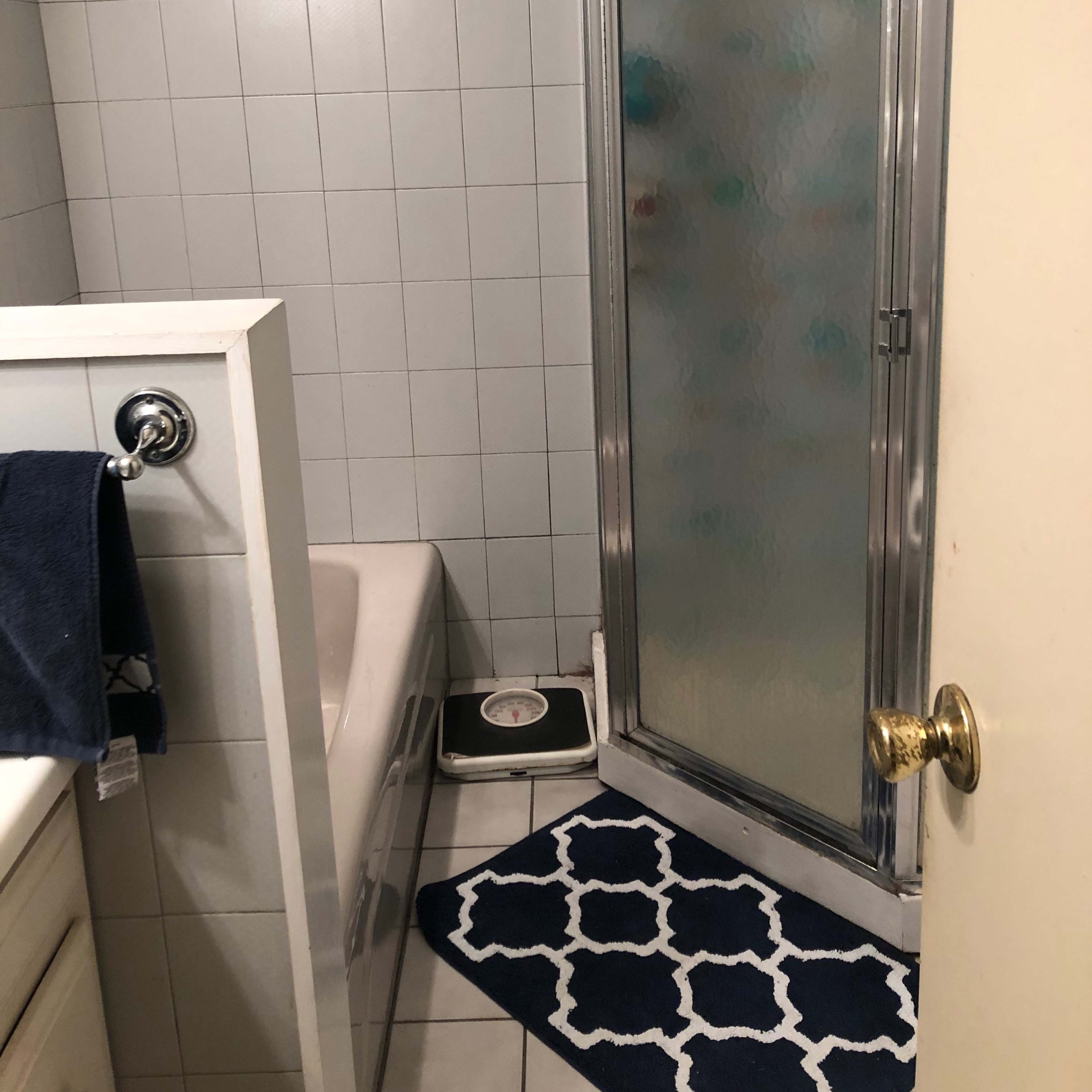 A bathroom with a shower stall, a bathtub, and a sink with a towel hanging on the wall.