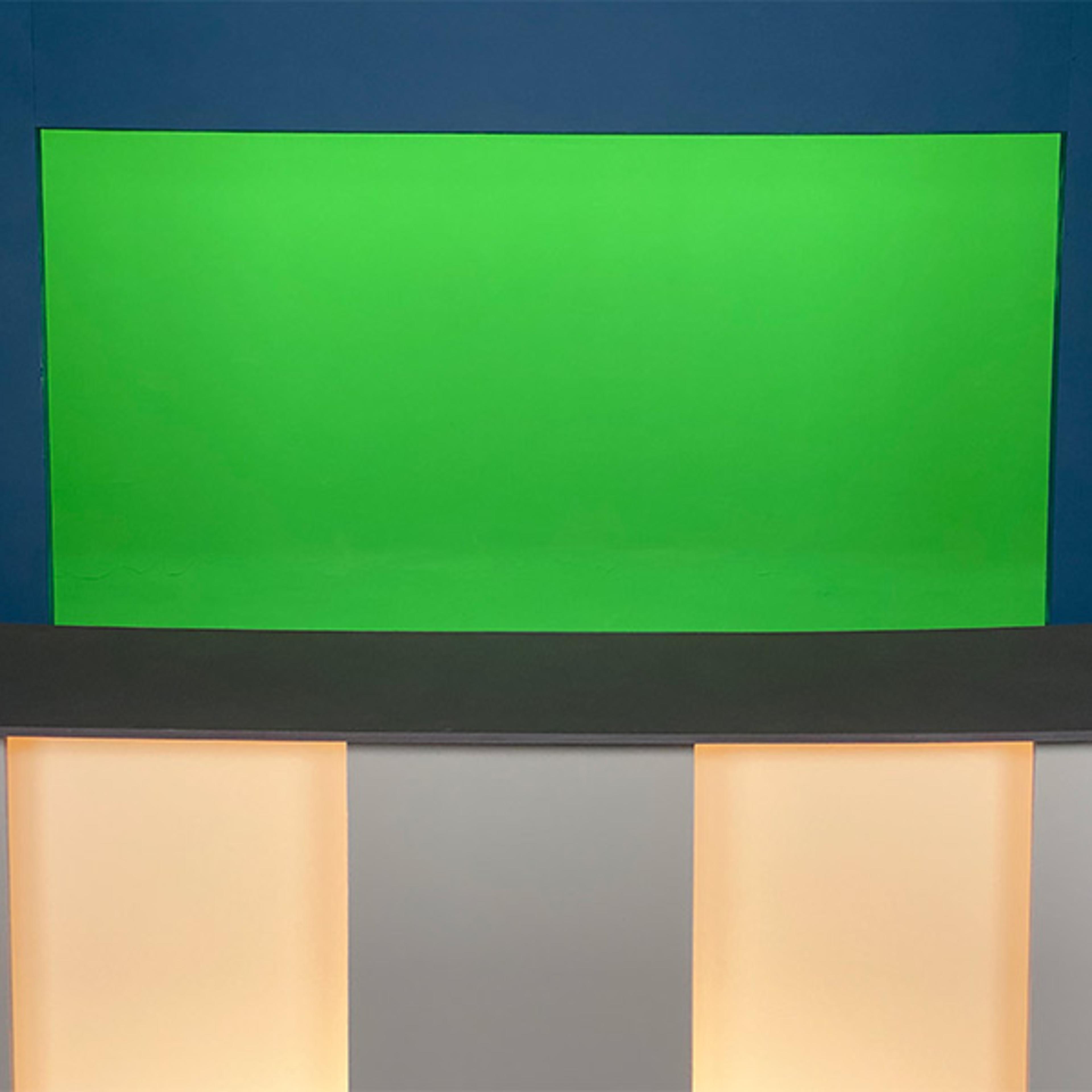 A studio setup features a green screen backdrop and a low, modern counter with illuminated sections.