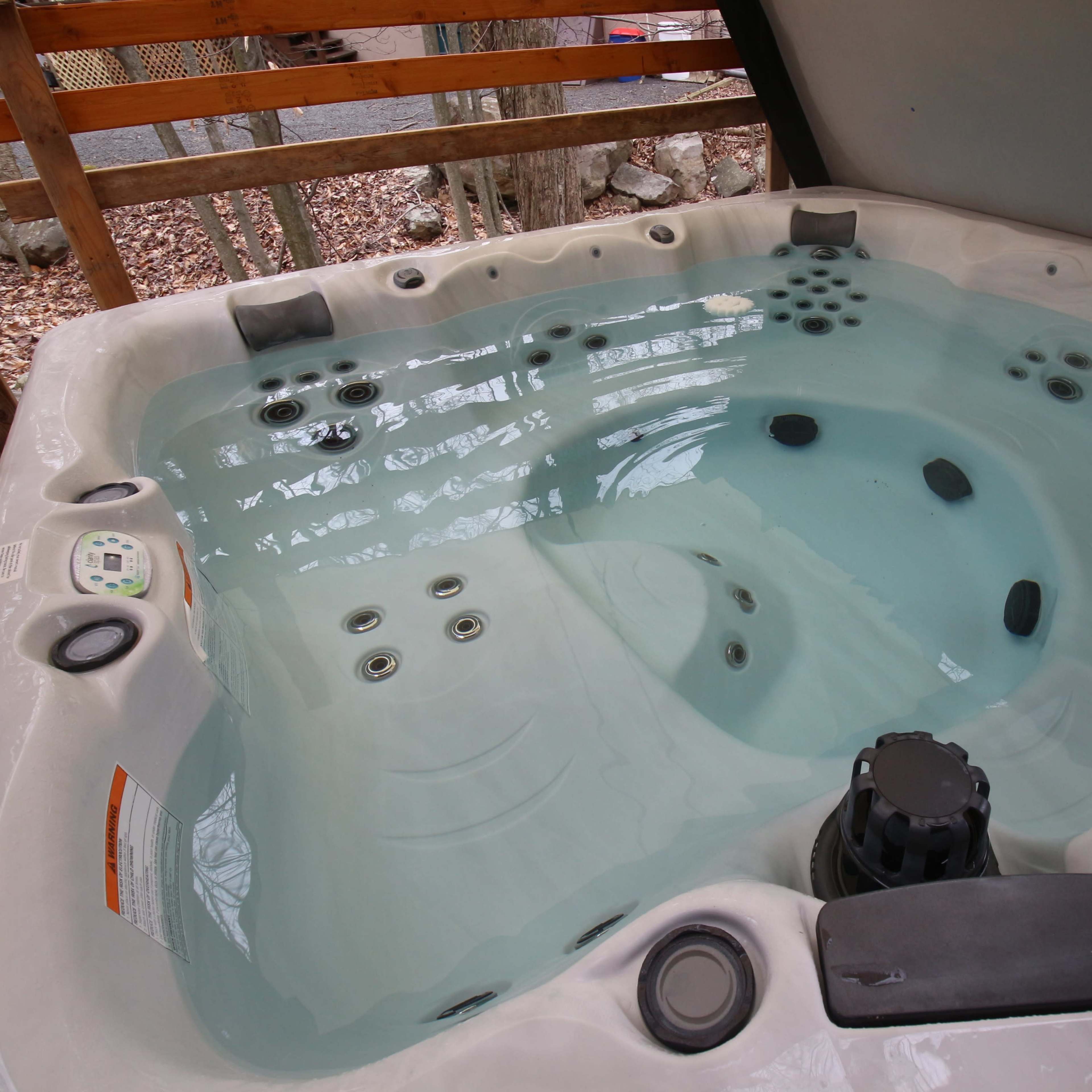A clean, empty hot tub filled with clear water and equipped with several jets.