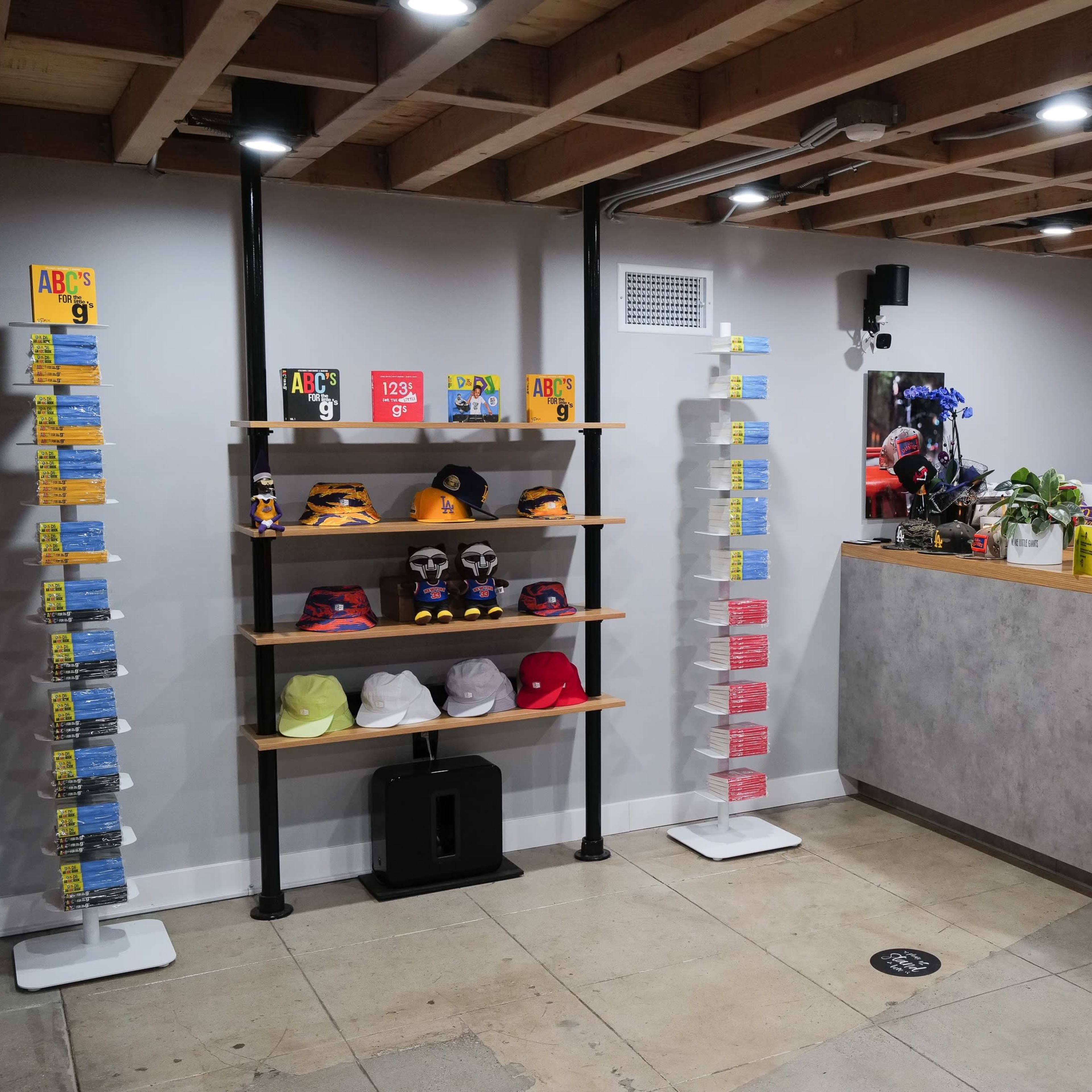 A retail space with shelves displaying hats and merchandise, a reception counter, and a wall clock.